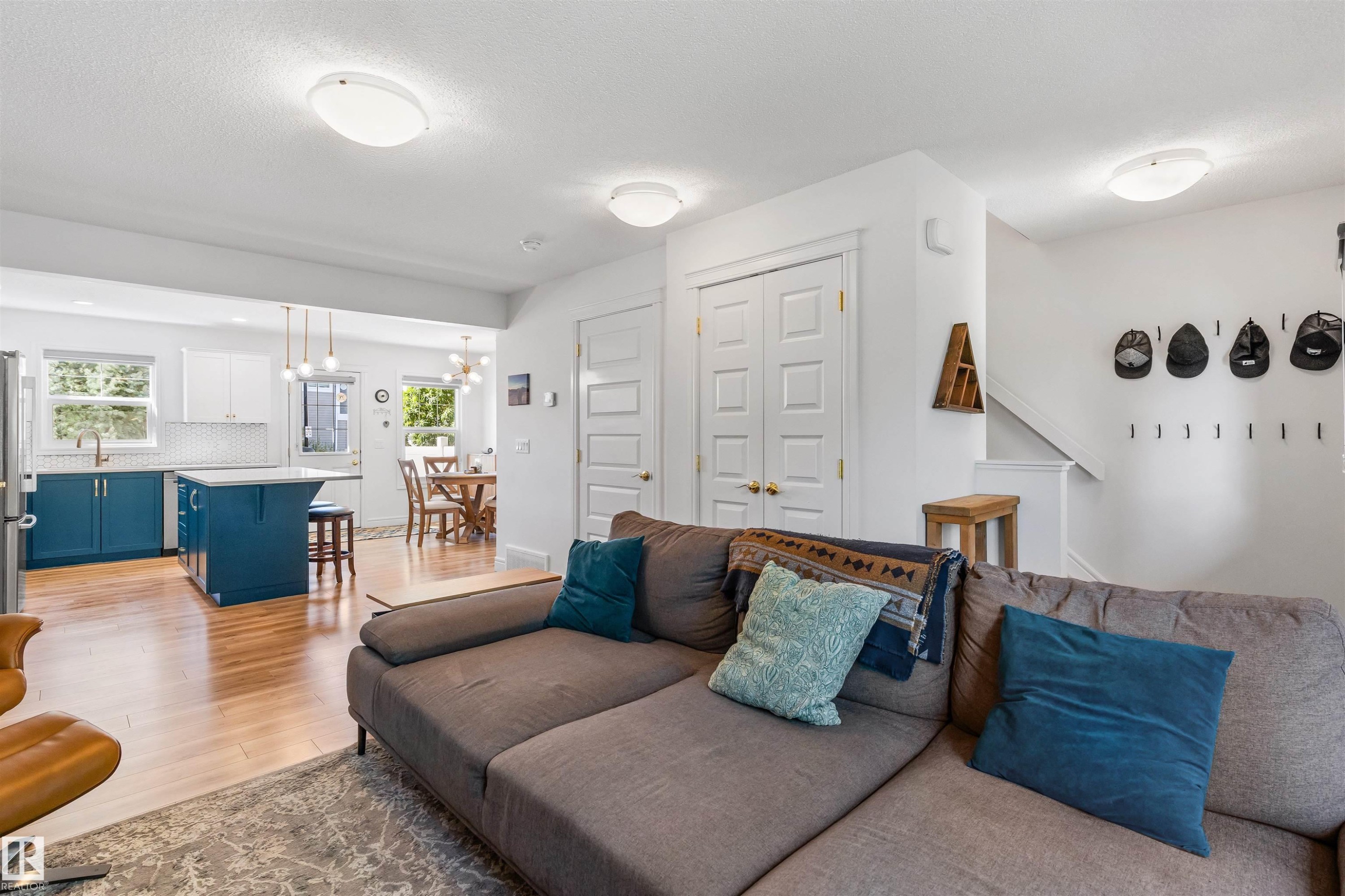 Open-concept living area with wood-finish flooring, recessed lighting, and a white color palette - #71 330 Bulyea Rd Nw, Edmonton, AB