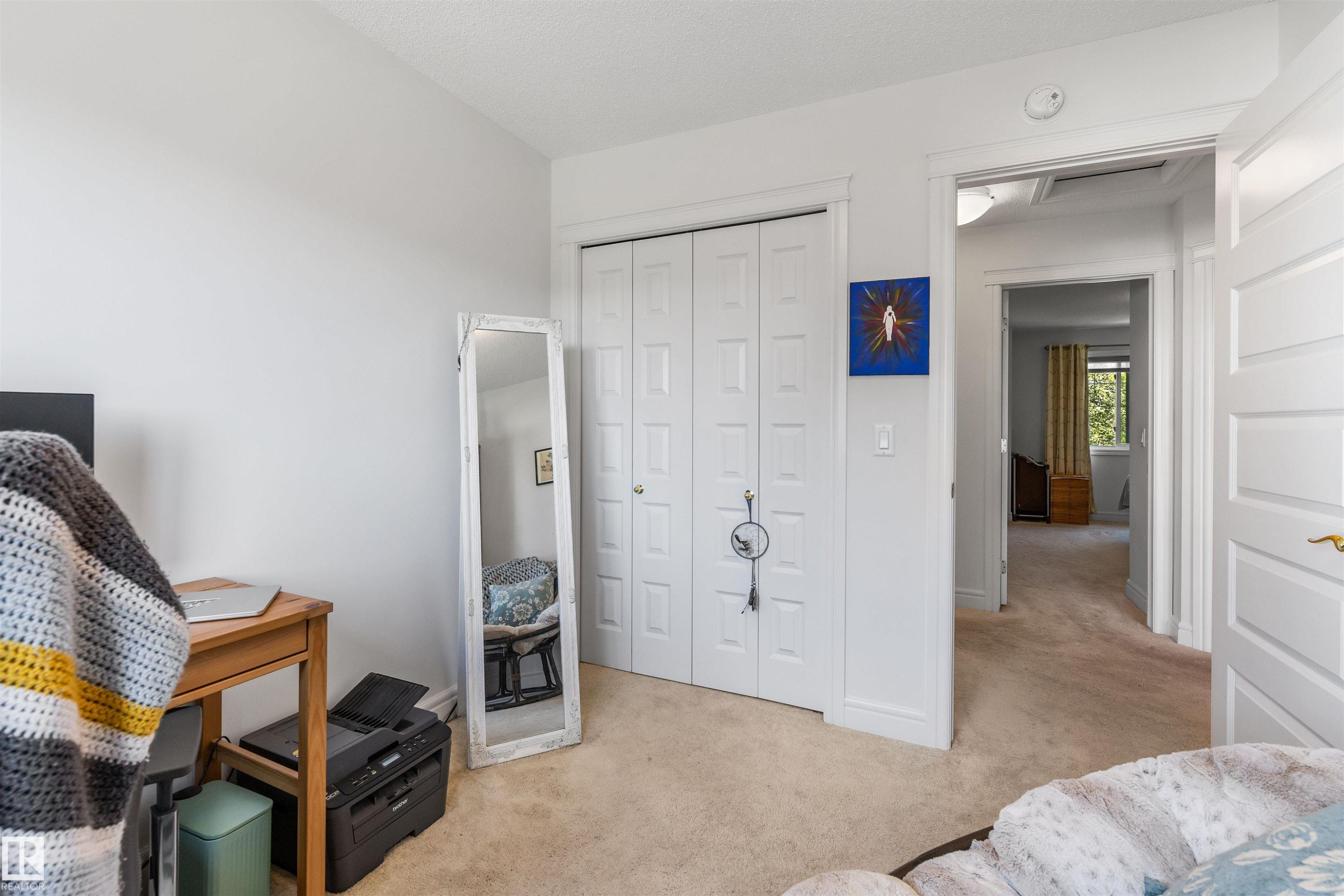 Plush carpeted flooring, white interior doors, and a double-door closet with paneled detailing - #71 330 Bulyea Rd Nw, Edmonton, AB