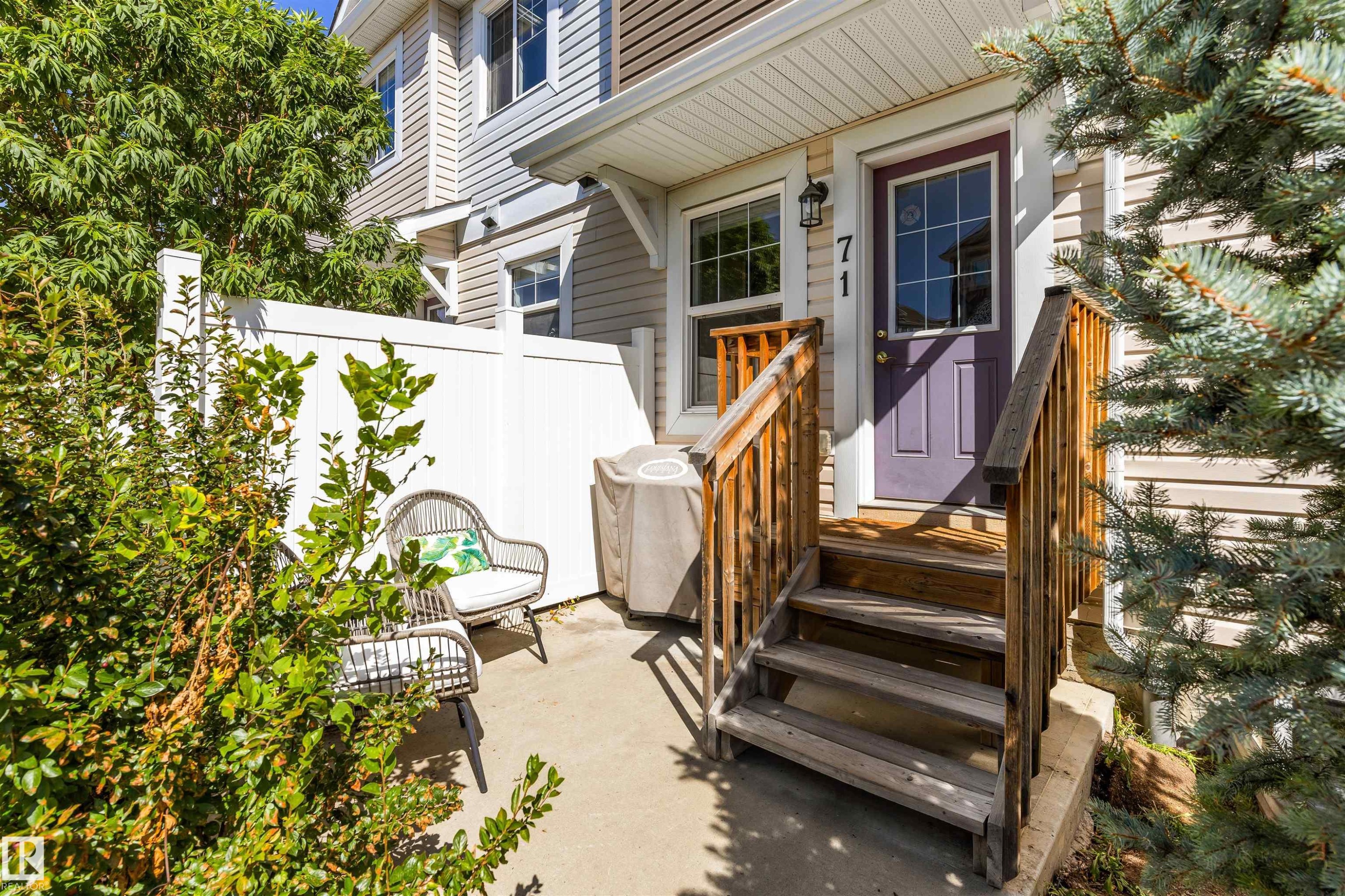 Private patio area with concrete flooring, white privacy fencing, and mature perimeter landscaping - #71 330 Bulyea Rd Nw, Edmonton, AB