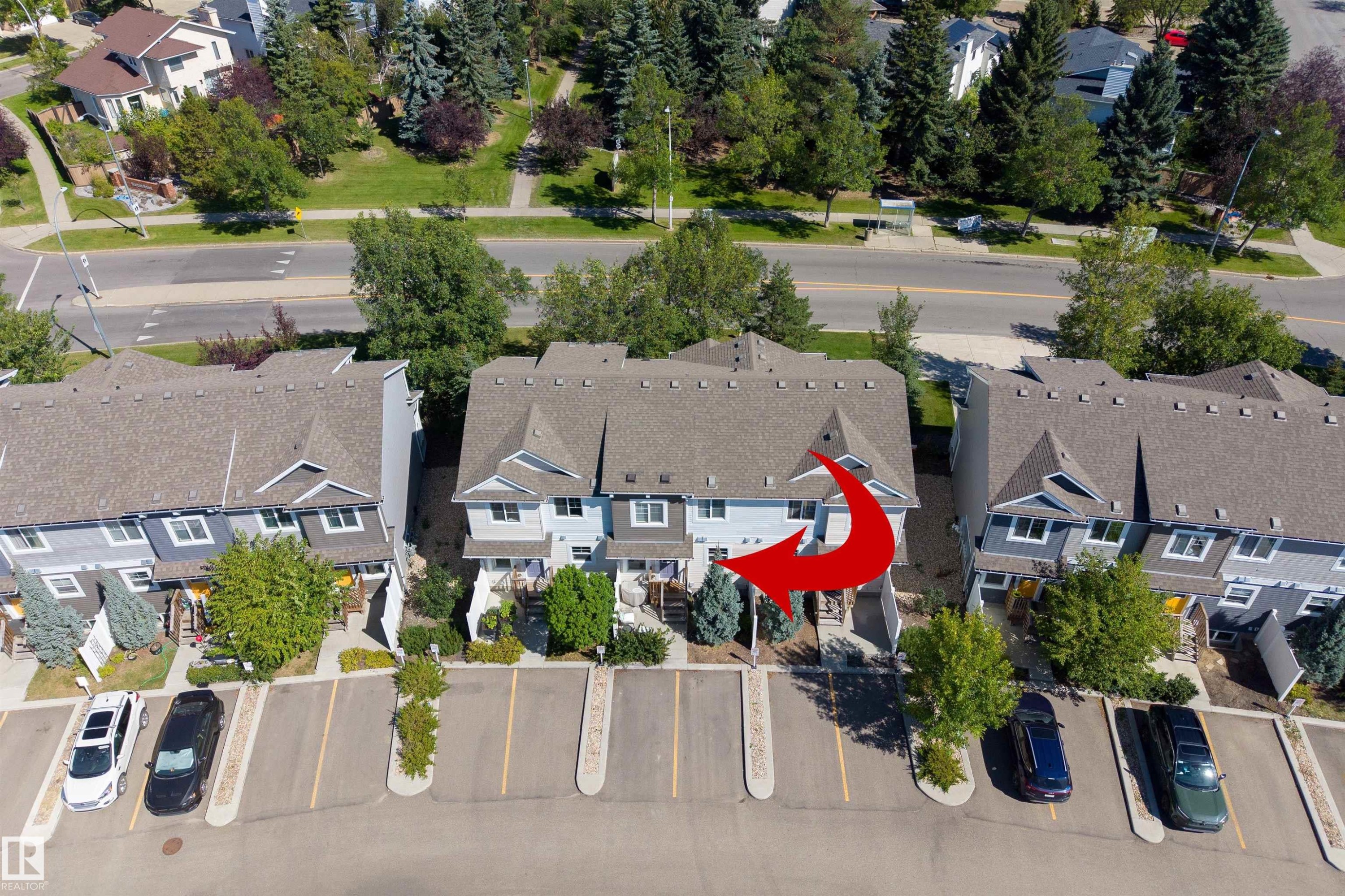 Multi-story townhouse with a light blue exterior, featuring a private entrance and a dedicated parking space - #71 330 Bulyea Rd Nw, Edmonton, AB