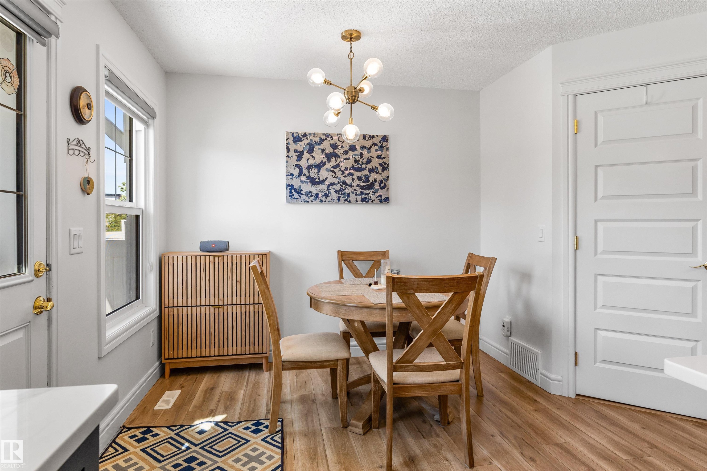 Wood-finish flooring, white paneled doors, and a decorative modern light fixture - #71 330 Bulyea Rd Nw, Edmonton, AB