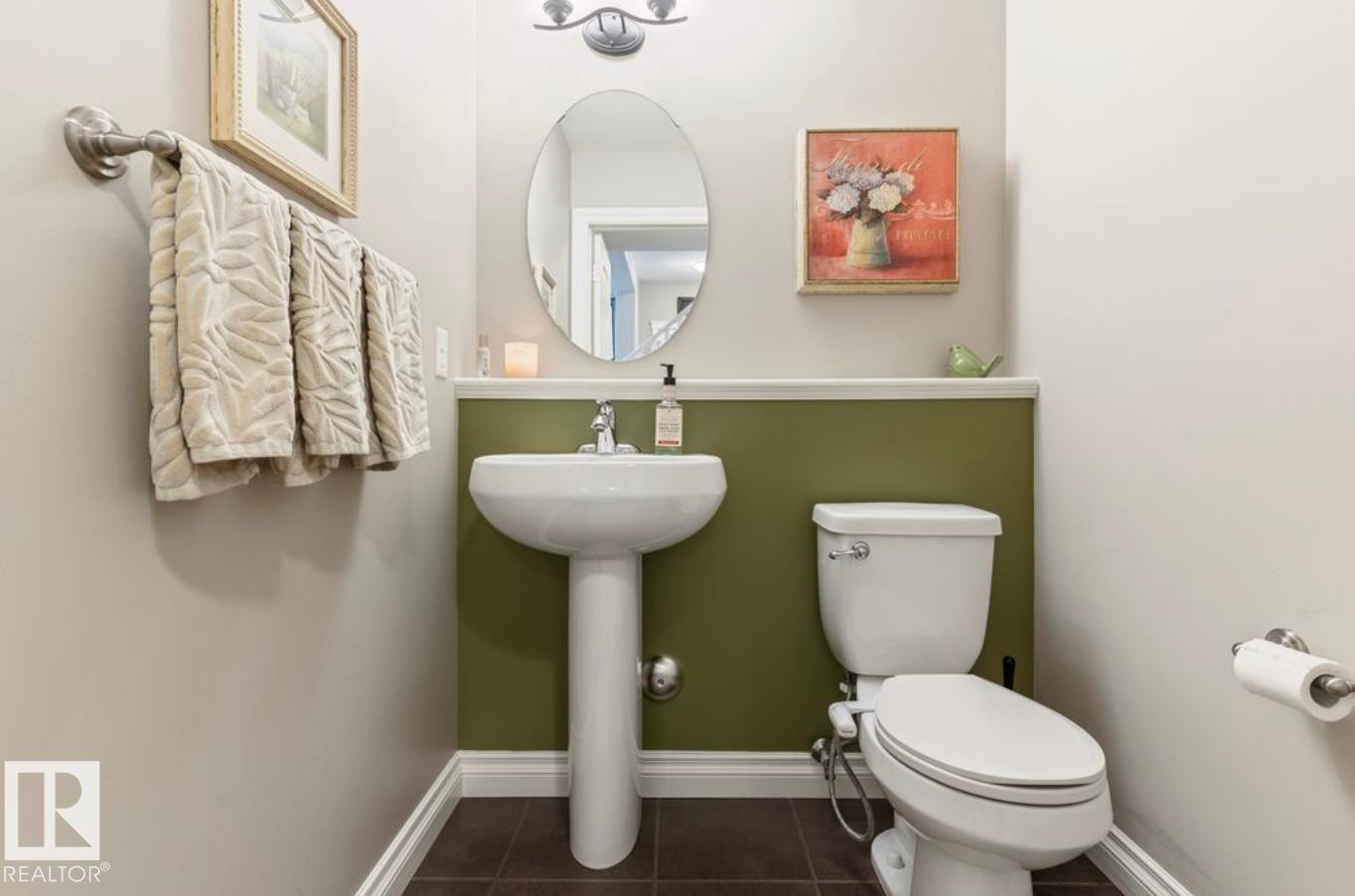 Pedestal sink with a polished chrome faucet, oval wall mirror, and overhead vanity light fixture - 22 Voleta Crest, Spruce Grove, AB
