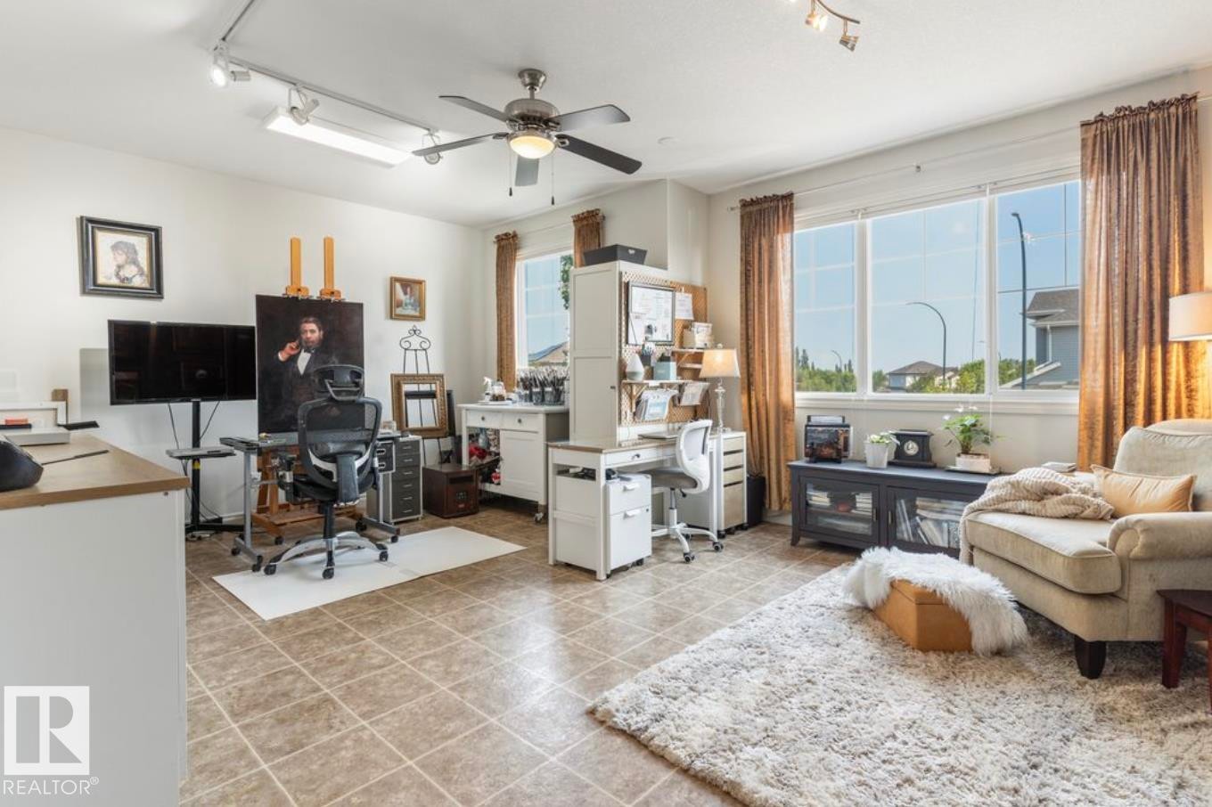 Expansive room featuring neutral-toned tile flooring, large windows, a ceiling fan, and track lighting - 22 Voleta Crest, Spruce Grove, AB
