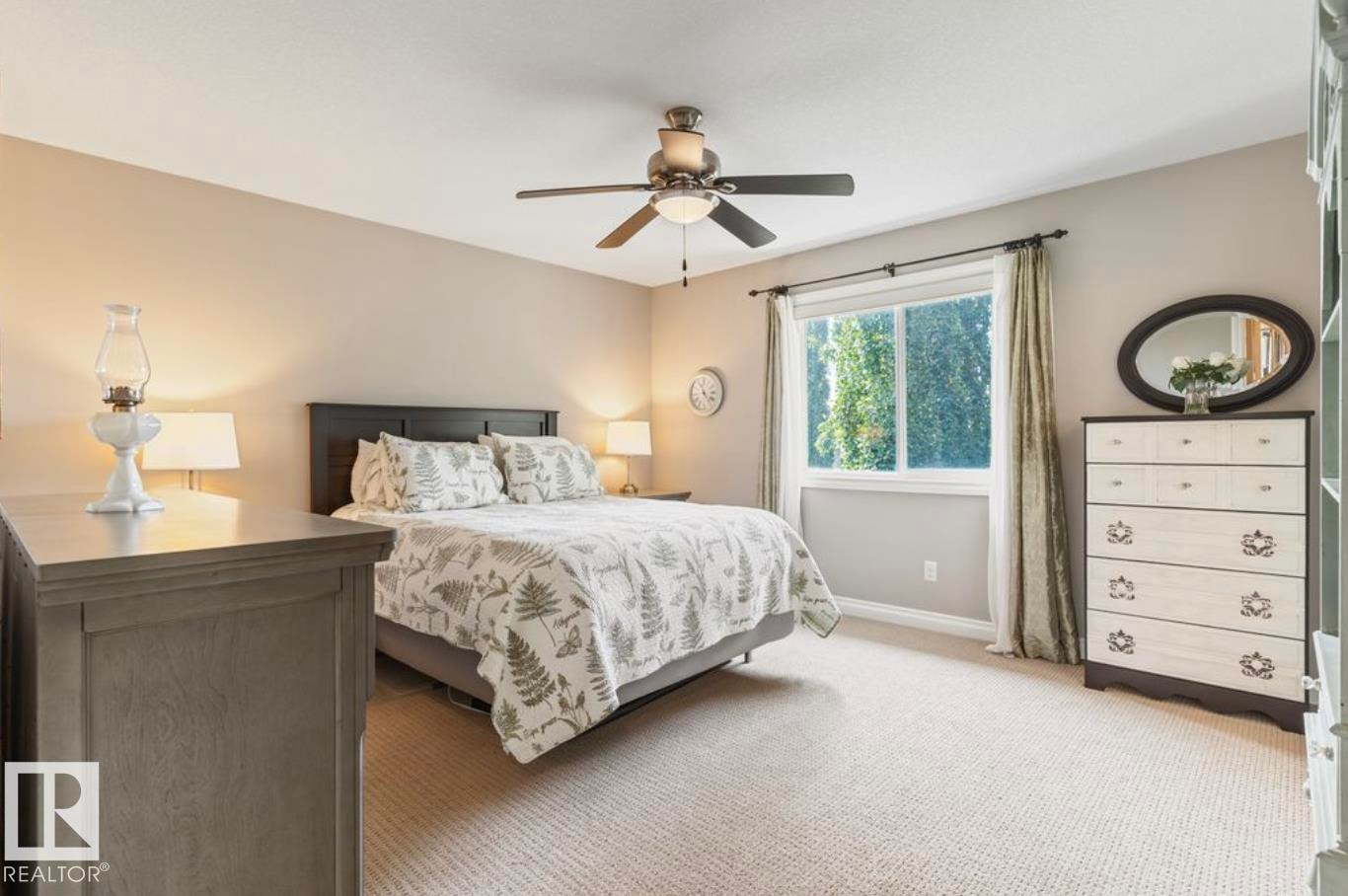Neutral wall paint, ceiling fan with integrated lighting, window with white trim, and light-colored carpeting - 22 Voleta Crest, Spruce Grove, AB