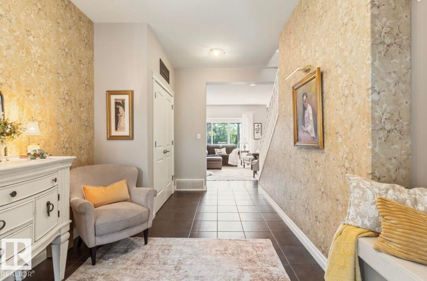 Tiled flooring entrance featuring textured wallpaper, white trim, and a staircase with white risers - 22 Voleta Crest, Spruce Grove, AB