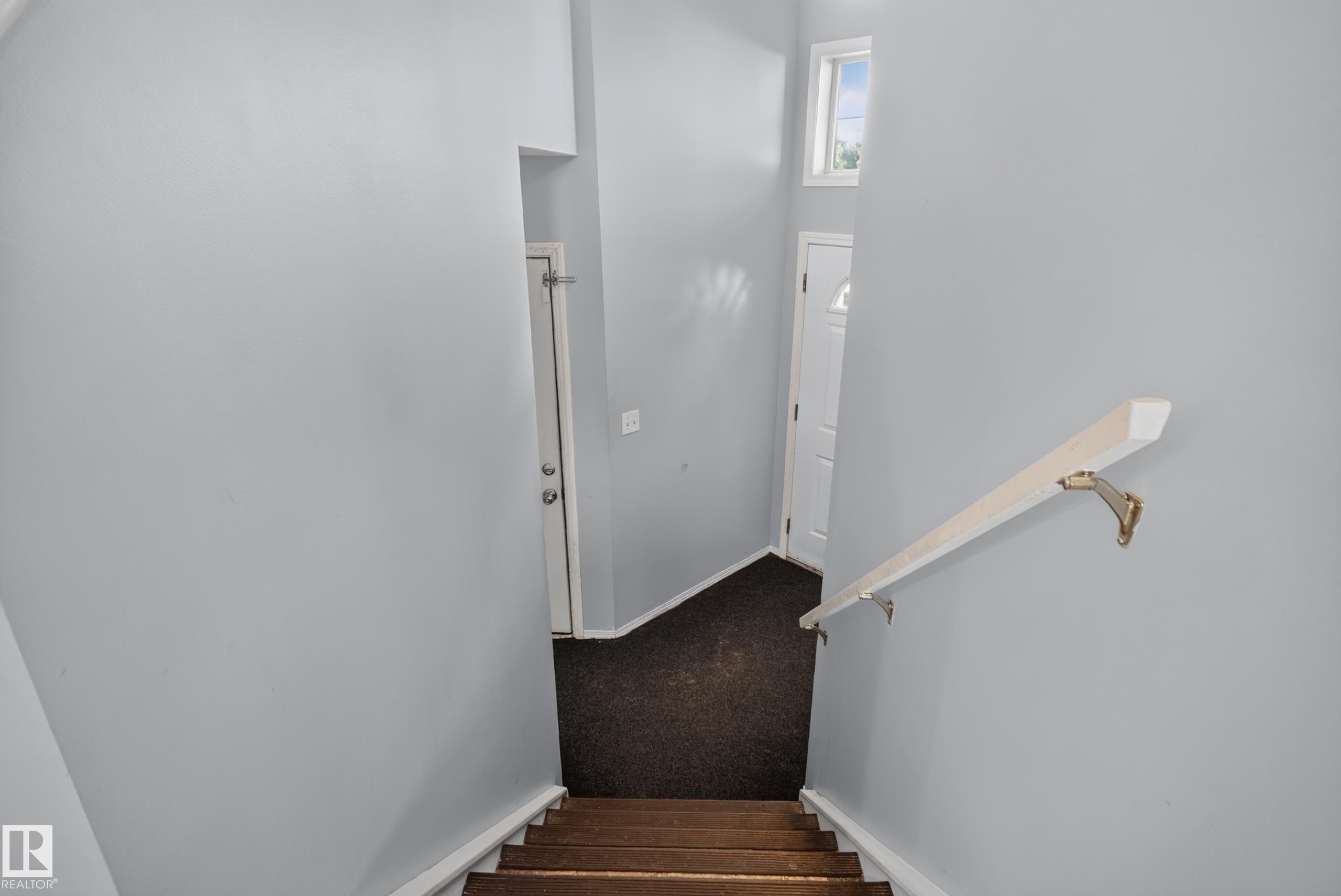Wood-finish stairs with a light-toned handrail - 13803 130A Avenue Nw, Edmonton, AB