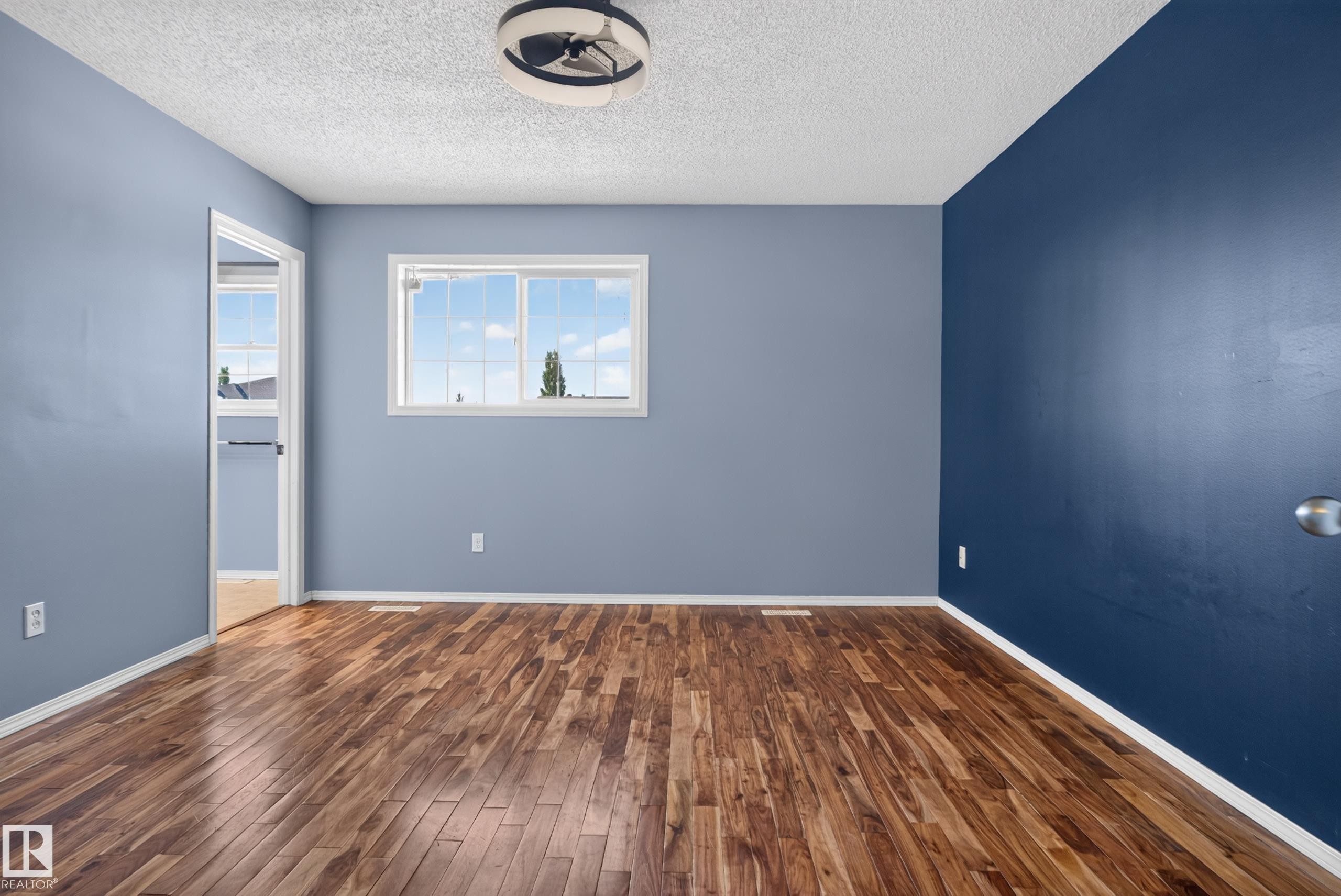 Wood-finish flooring, white window trim, white baseboards, and a ceiling-mounted light fixture - 13803 130A Avenue Nw, Edmonton, AB