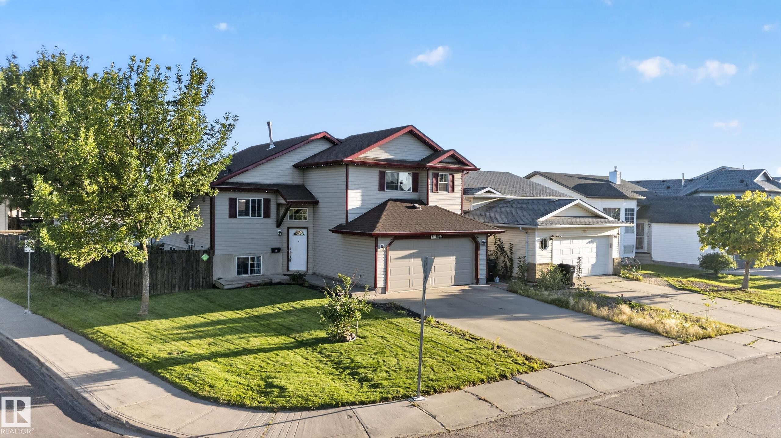 Two-story exterior with a two-car garage, front lawn, and mature trees - 13803 130A Avenue Nw, Edmonton, AB