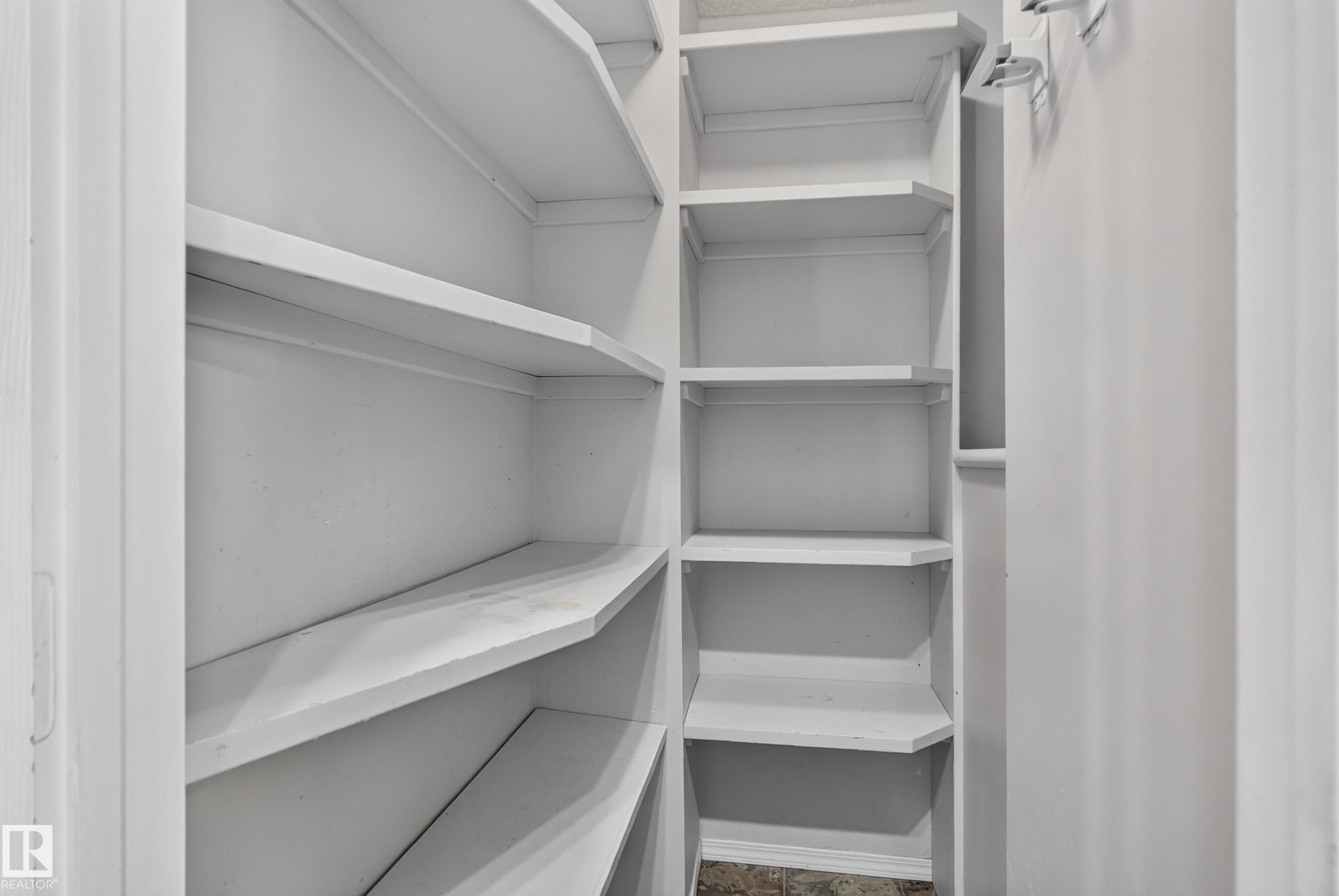Built-in shelving with multiple levels, painted white finishes, and a corner configuration - 13803 130A Avenue Nw, Edmonton, AB