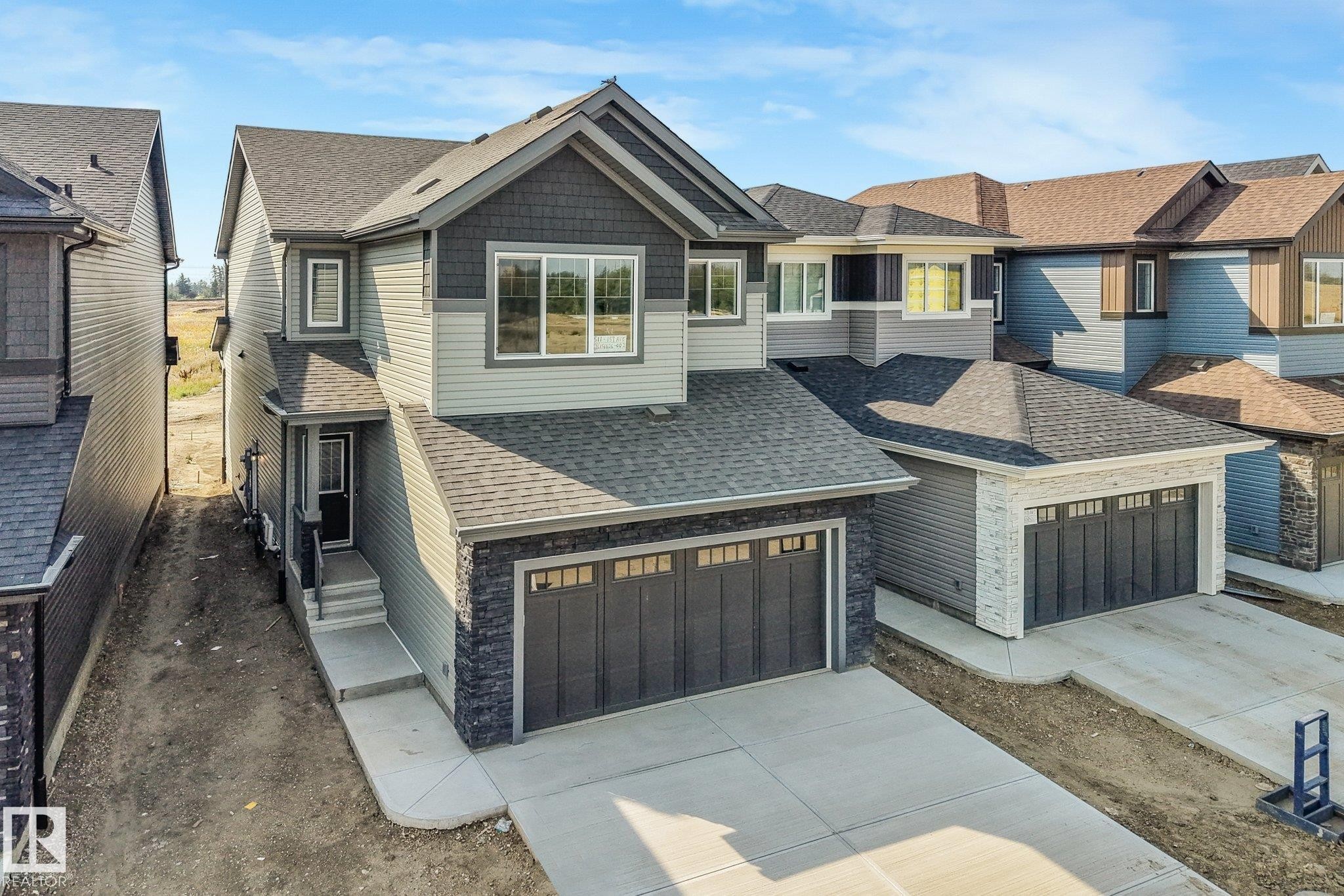 Two-story residence featuring a gray shingle roof and a two-car garage - 511 157 Avenue Ne, Edmonton, AB