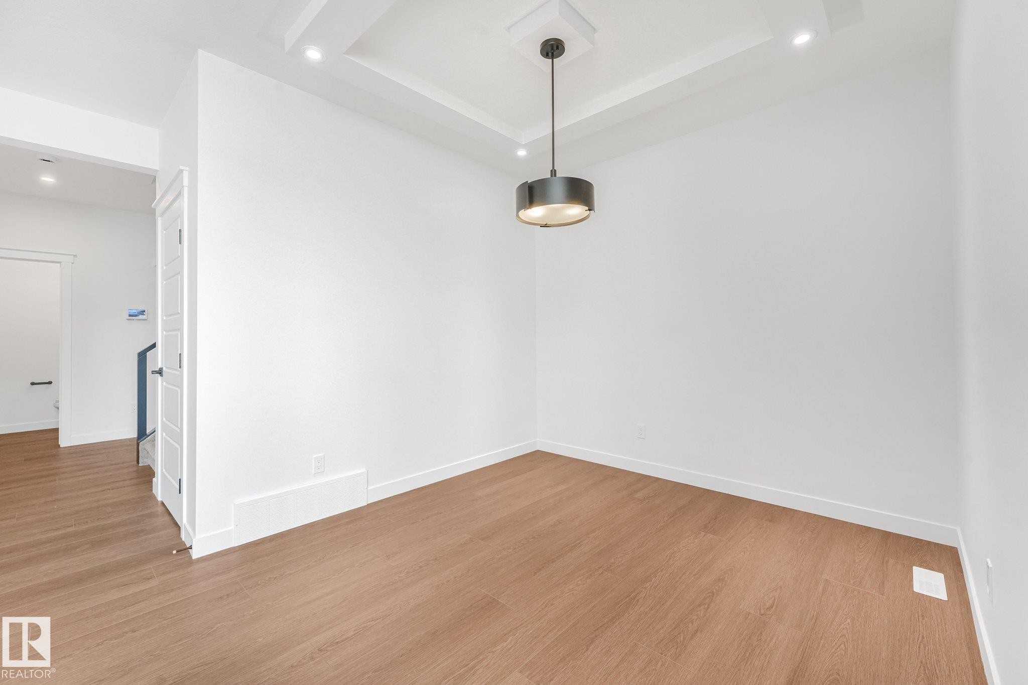 Tray ceiling with recessed lighting and a modern pendant fixture - 511 157 Avenue Ne, Edmonton, AB