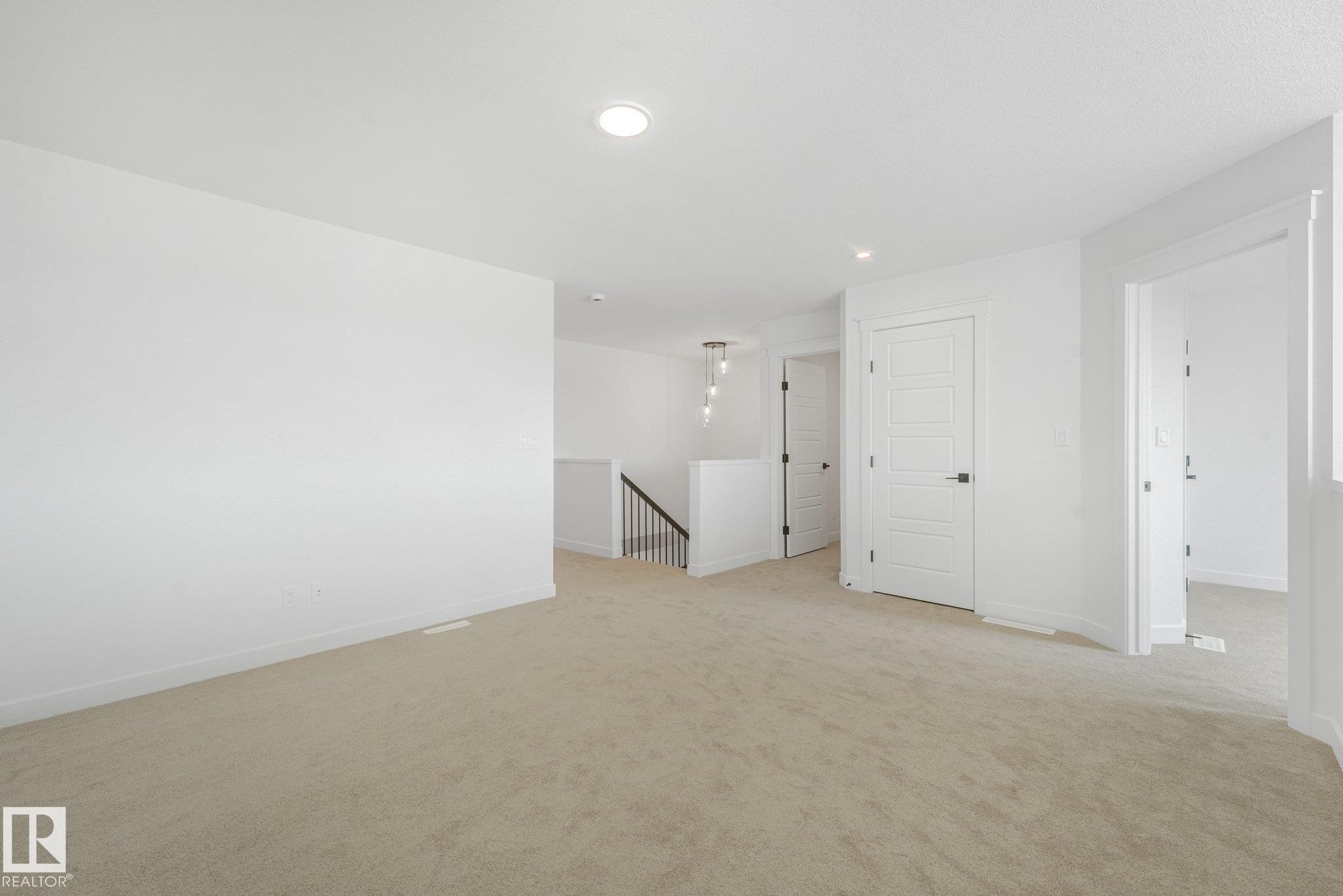 Carpeted flooring, contemporary interior doors, recessed lighting, and a modern stair railing with spindle balusters - 511 157 Avenue Ne, Edmonton, AB