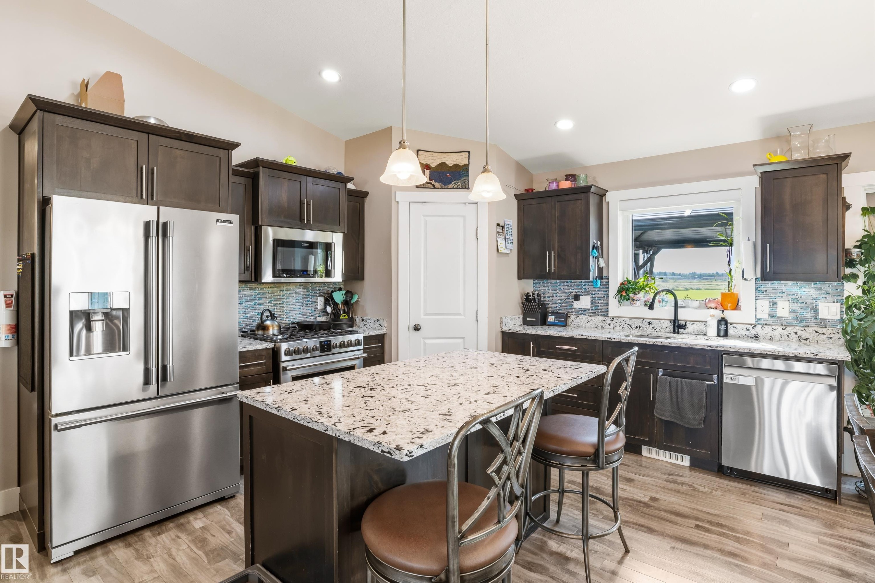 Chef's kitchen featuring stainless steel French-door refrigerator, gas range with stainless steel hood, and dishwasher - 4927 57 Avenue, Cold Lake, AB