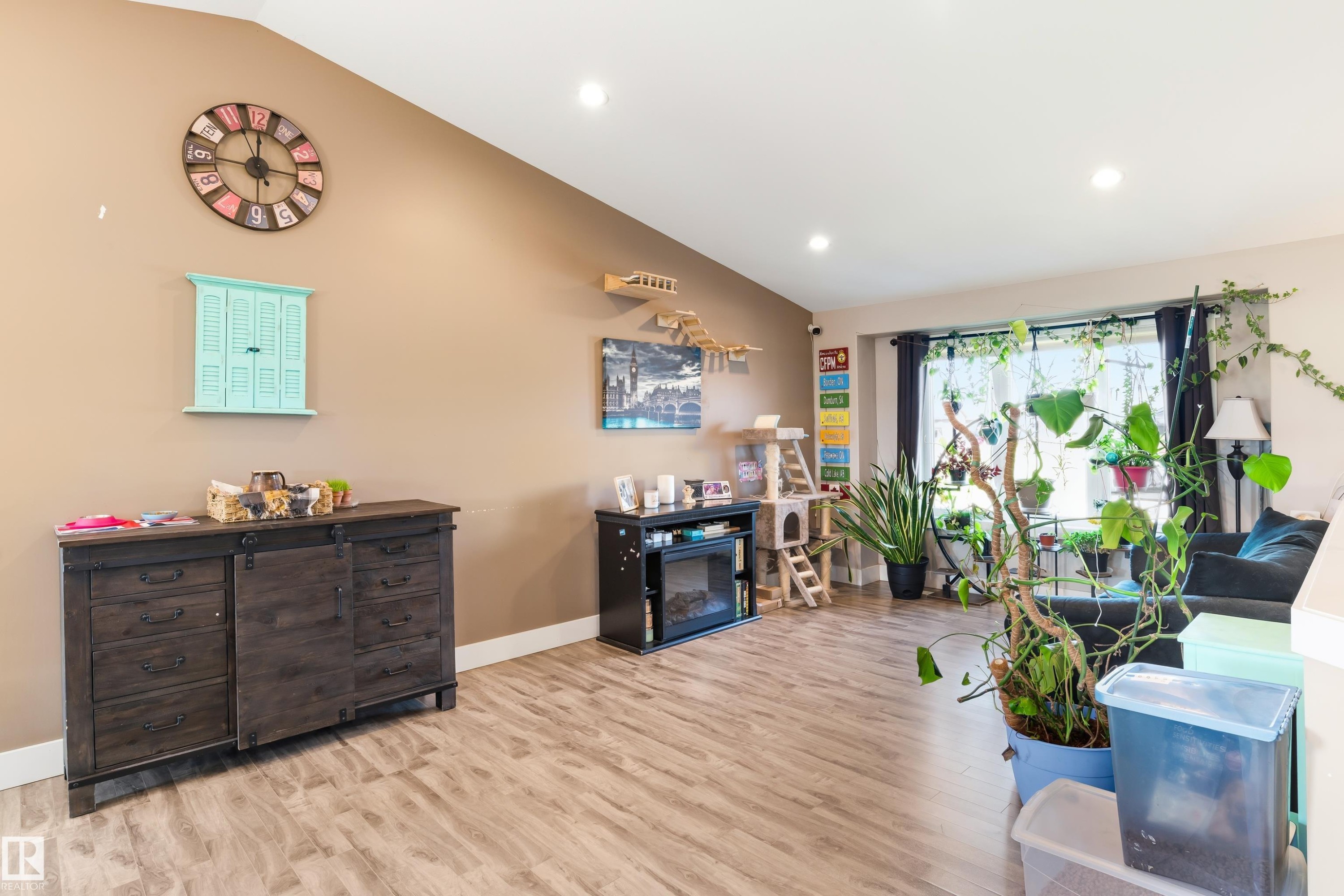Vaulted ceiling, recessed lighting, wood-finish flooring, a large window, and light-toned wall paint - 4927 57 Avenue, Cold Lake, AB
