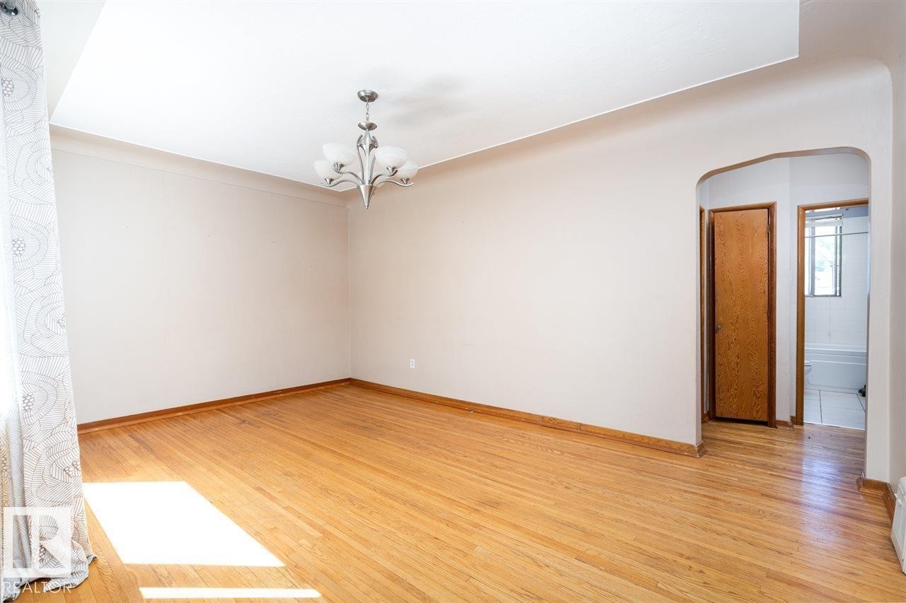 Hardwood flooring, chandelier lighting, arched doorway, and light-toned walls - 11730 125 Street Nw, Edmonton, AB