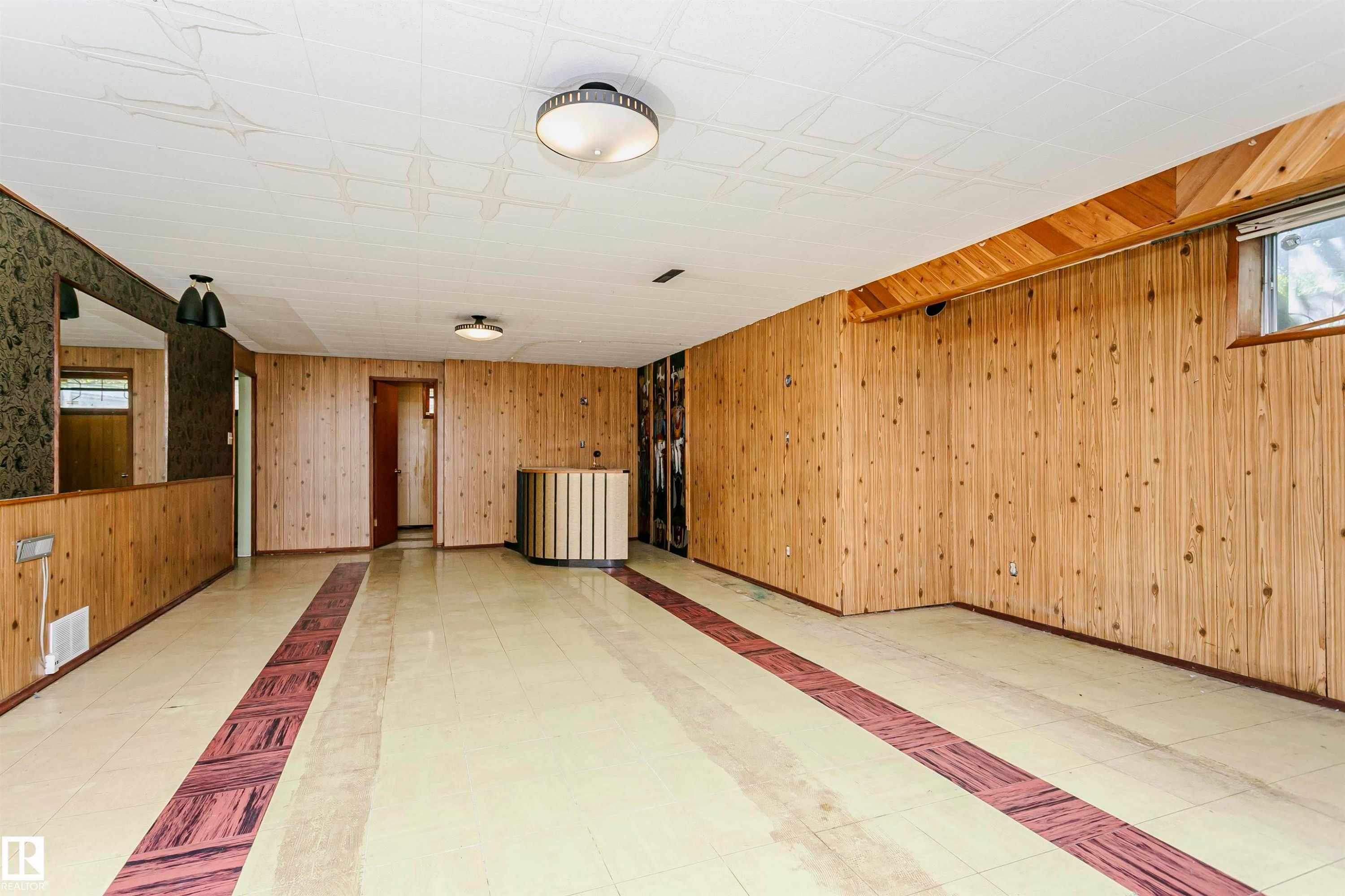 Wood-paneled walls with patterned flooring, featuring a built-in bar area and recessed lighting - 11440 44A Avenue Nw, Edmonton, AB
