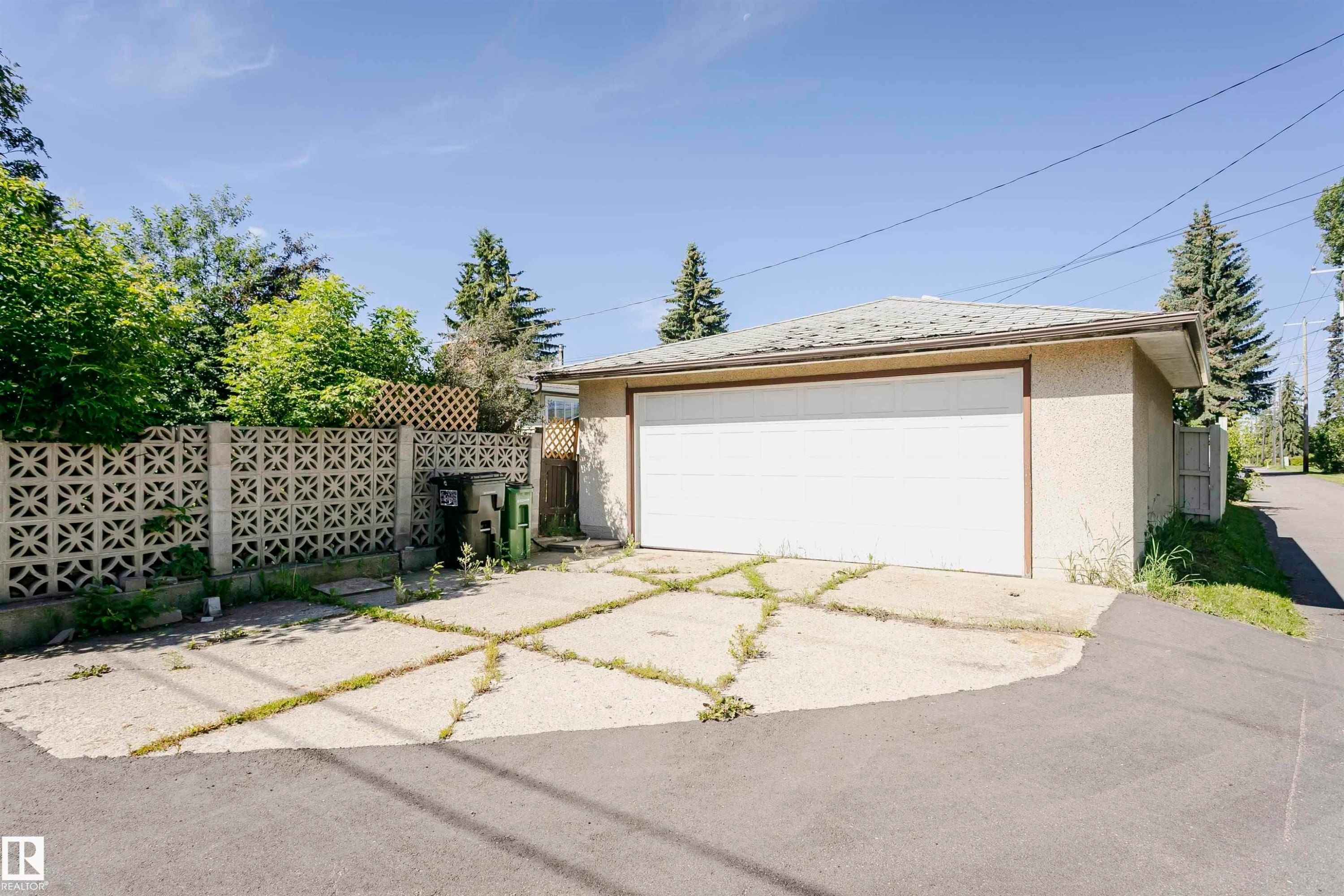 Detached garage with a white overhead door, stucco exterior, and a shingle roof - 11440 44A Avenue Nw, Edmonton, AB