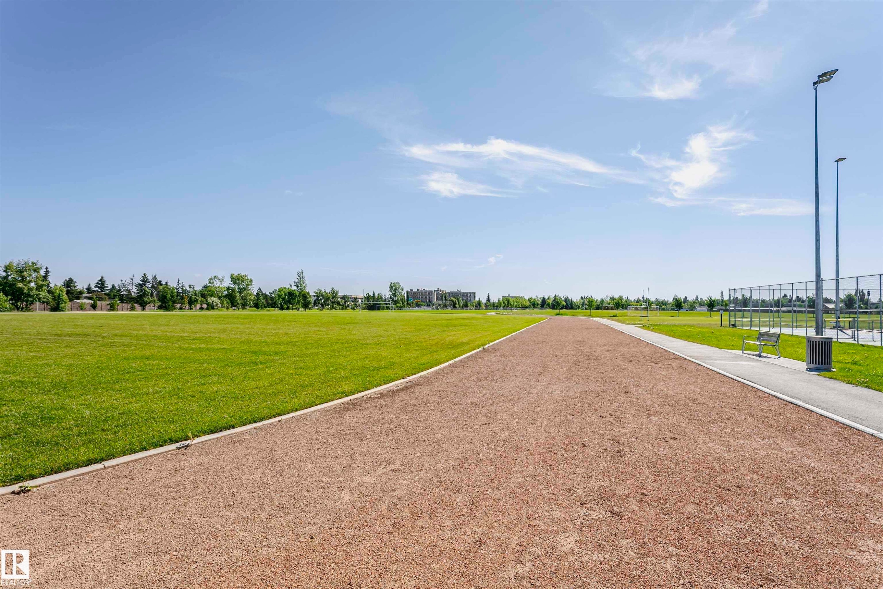 Expansive green space featuring a walking path, paved pathway, and distant athletic courts - 11440 44A Avenue Nw, Edmonton, AB