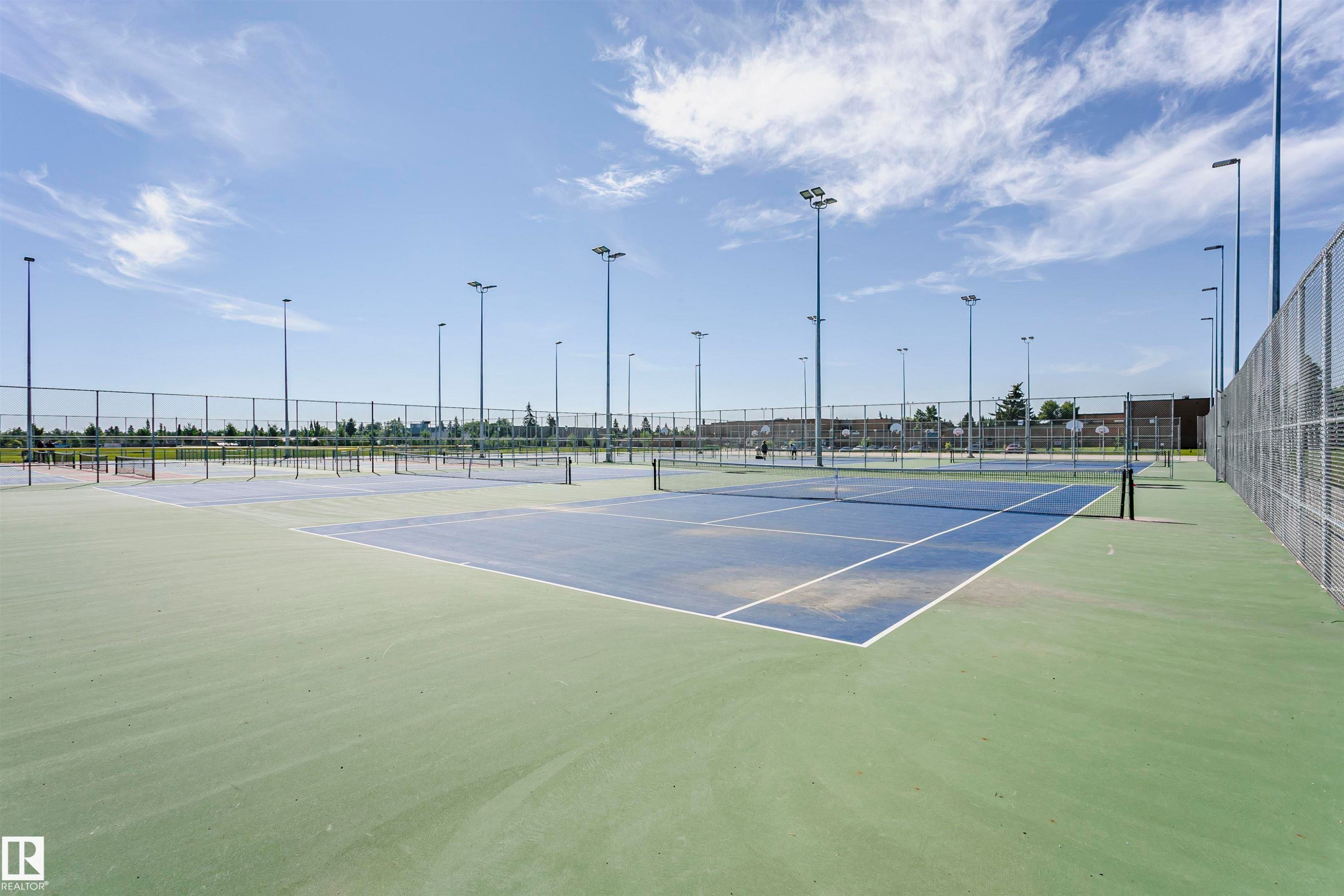 Multiple outdoor tennis courts with chain-link fencing, surrounded by tall light poles - 11440 44A Avenue Nw, Edmonton, AB