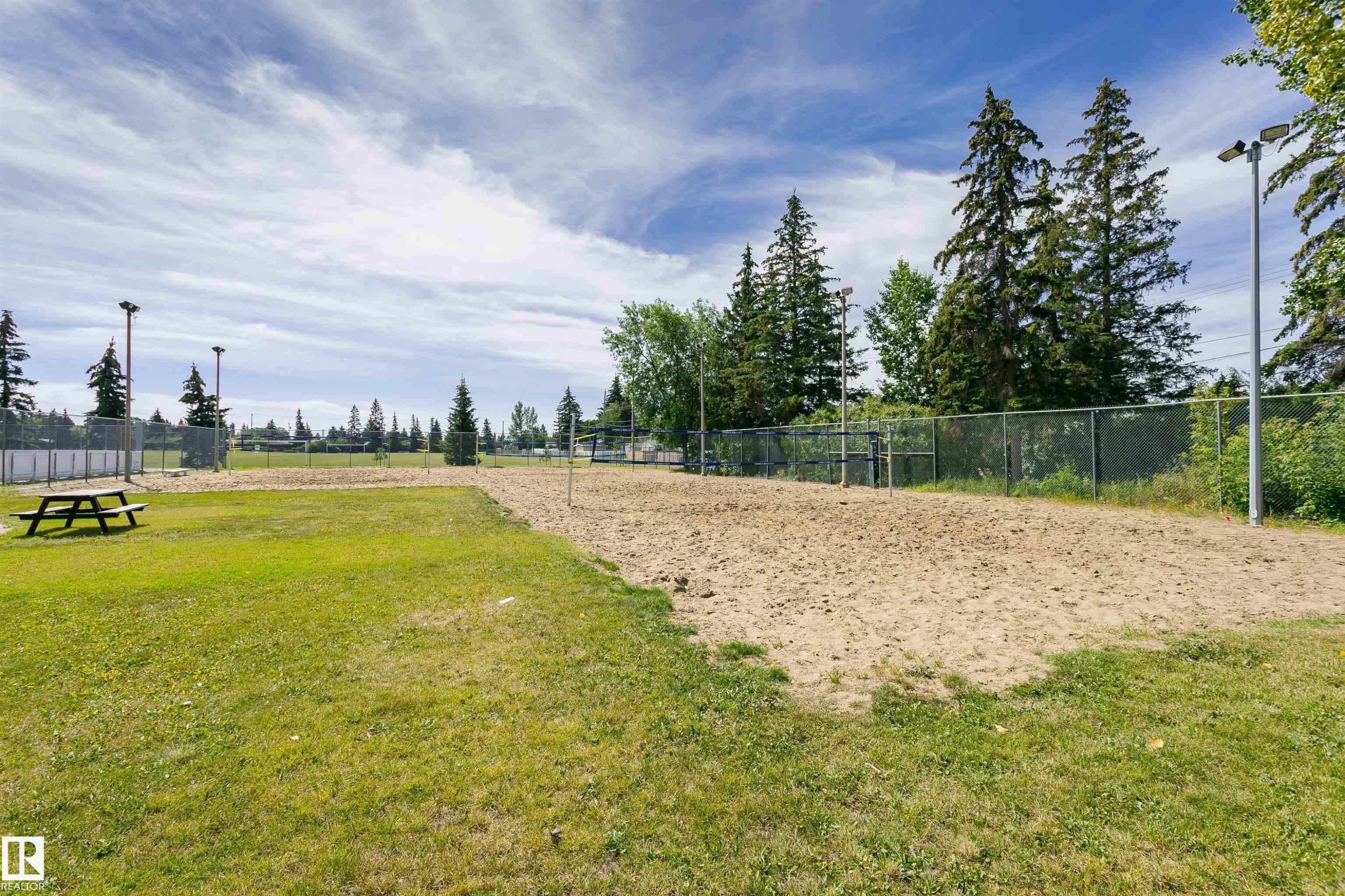 Sand volleyball court bordered by a grassy area and mature trees - 11440 44A Avenue Nw, Edmonton, AB