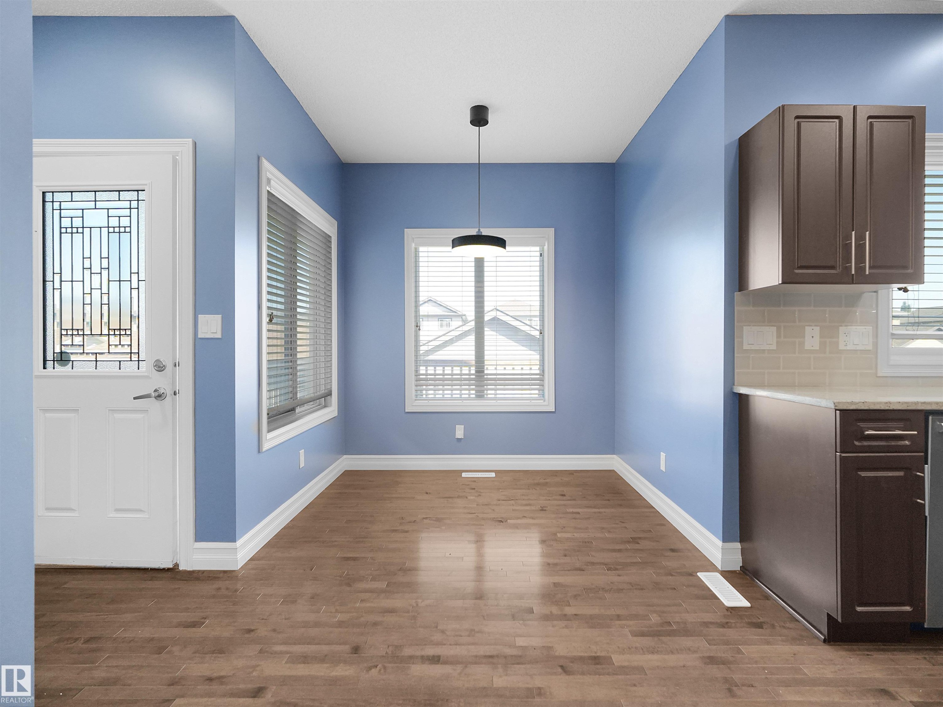 Wood-finish flooring, white trim, and a modern pendant light fixture - 5190 1B Avenue Sw, Edmonton, AB