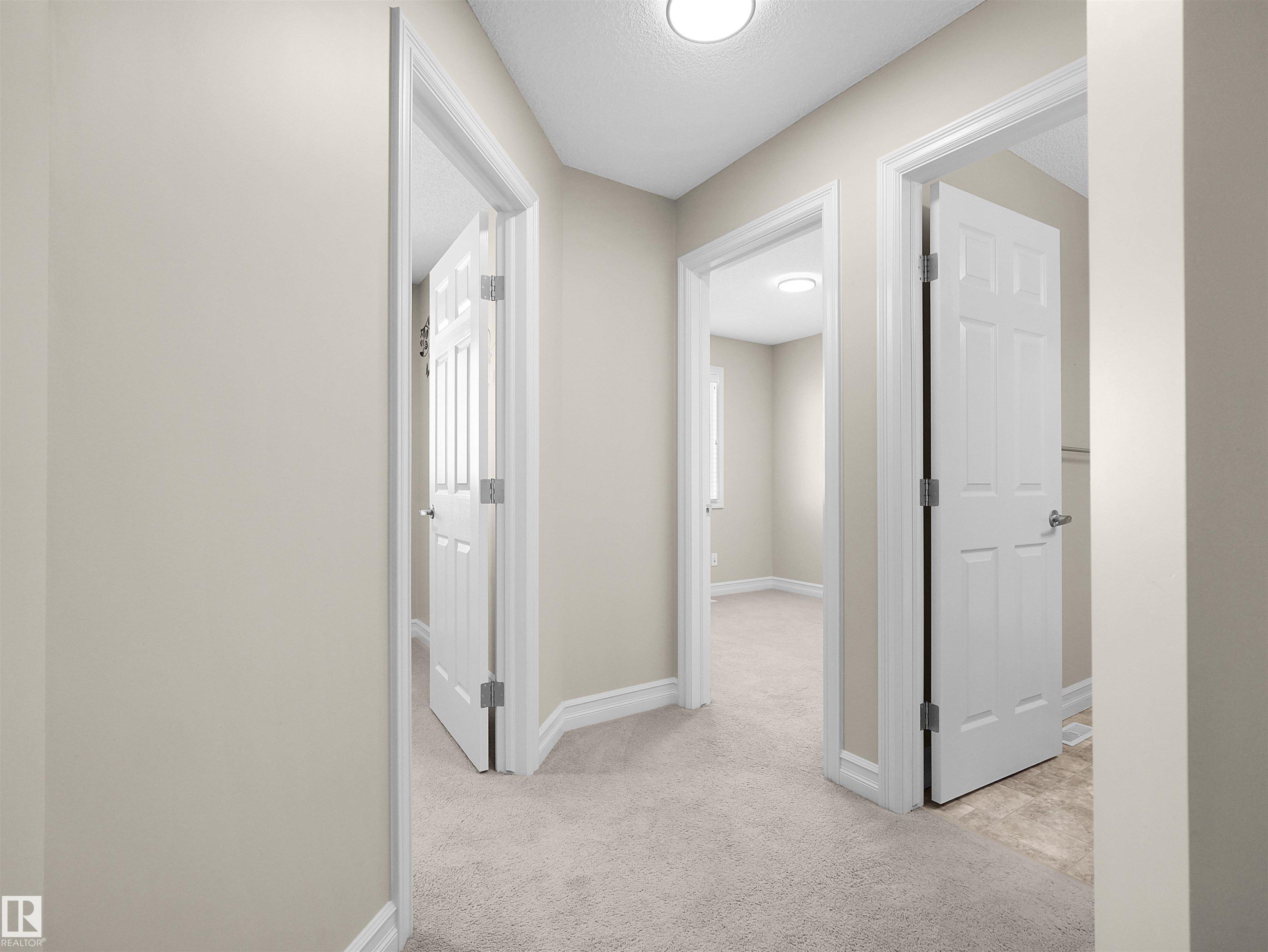 Carpeted hallway with light neutral walls, white trim, and recessed ceiling lighting - 5190 1B Avenue Sw, Edmonton, AB
