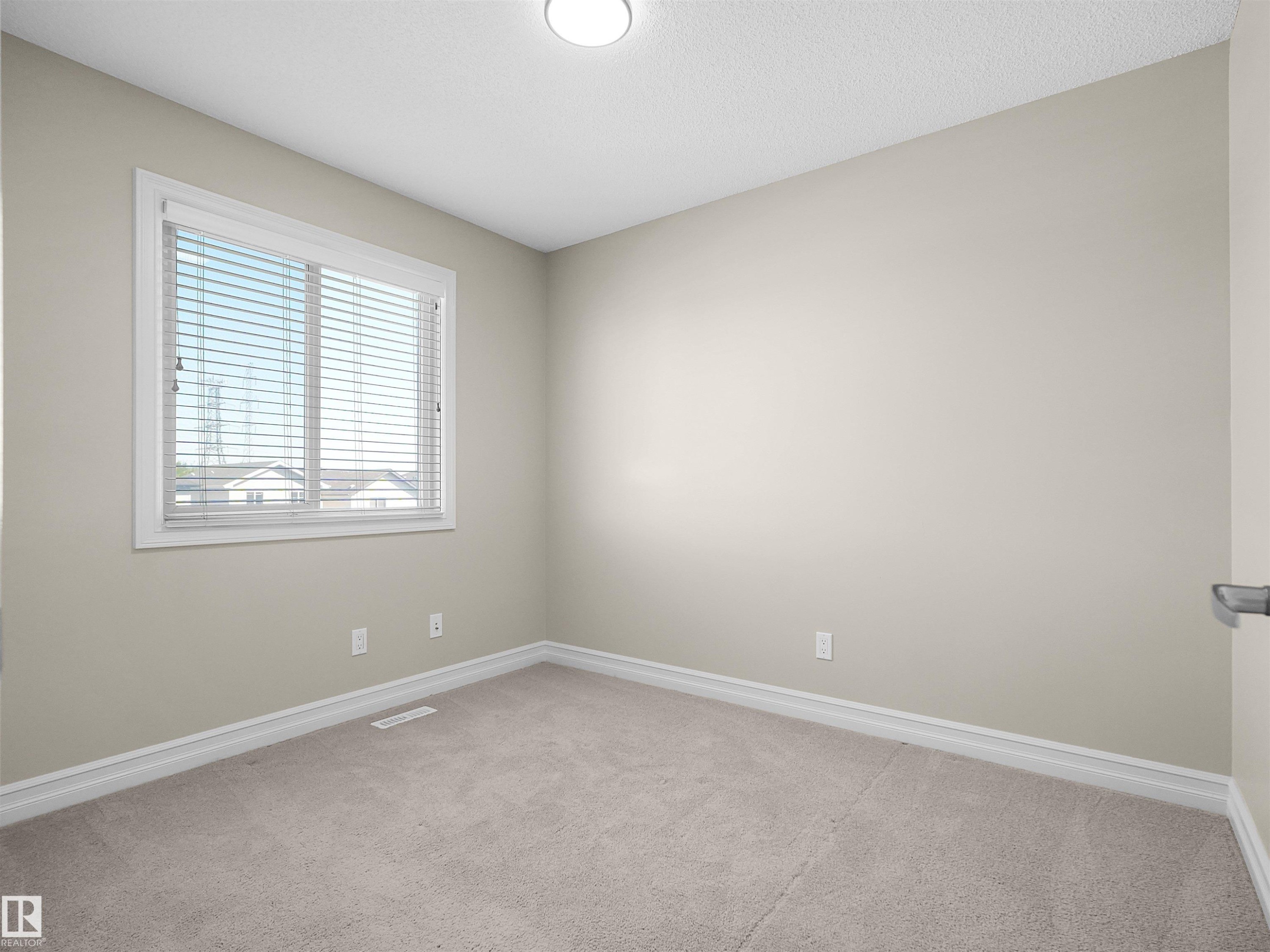 Neutral wall color, light-toned carpet flooring, white trim, and a window with horizontal blinds - 5190 1B Avenue Sw, Edmonton, AB
