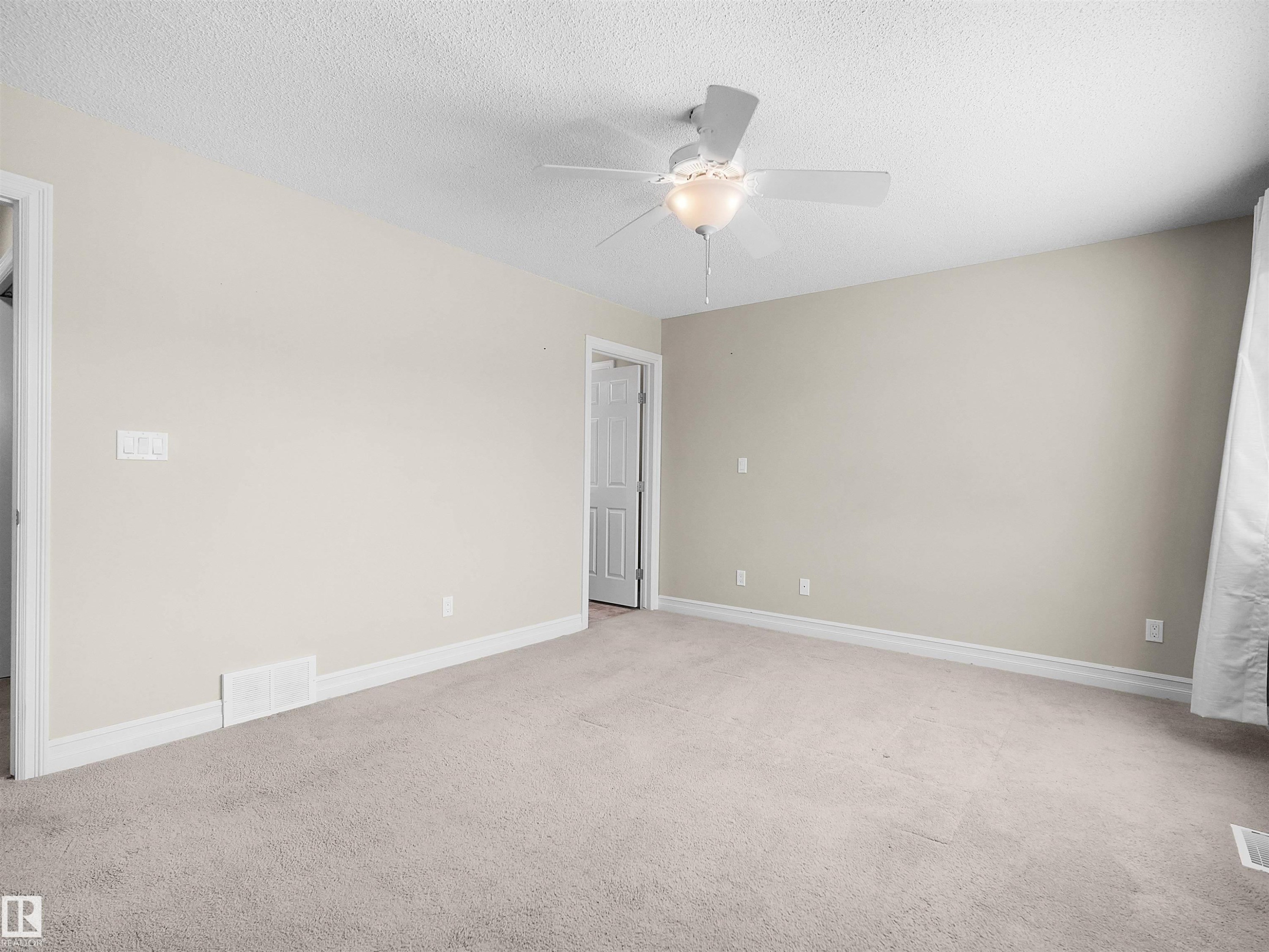 Neutral-toned walls, light-colored carpeting, white trim, and a ceiling fan with integrated lighting - 5190 1B Avenue Sw, Edmonton, AB