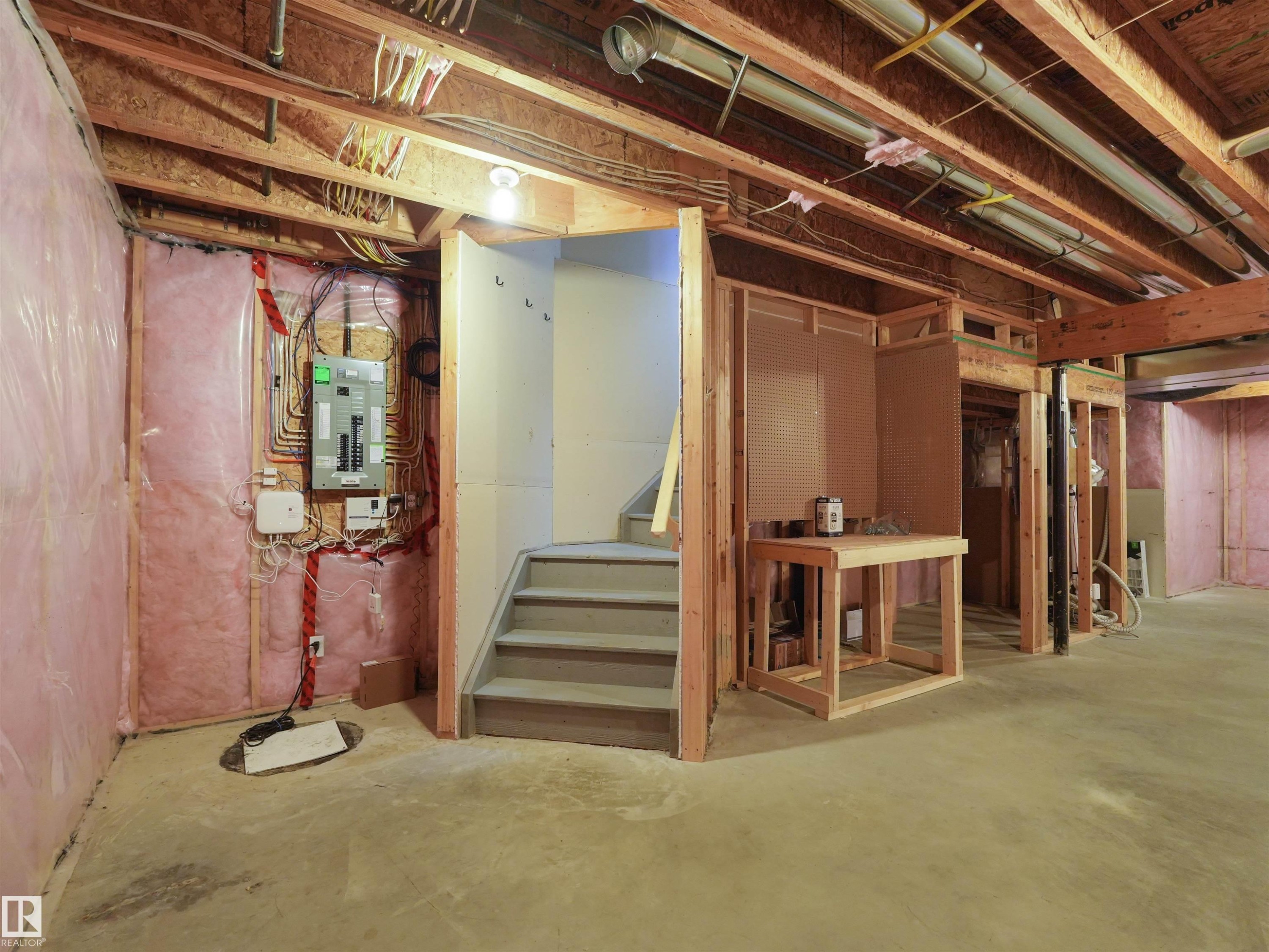 Exposed ceiling joists, concrete flooring, insulated walls, framed interior walls, and visible electrical panel - 5190 1B Avenue Sw, Edmonton, AB