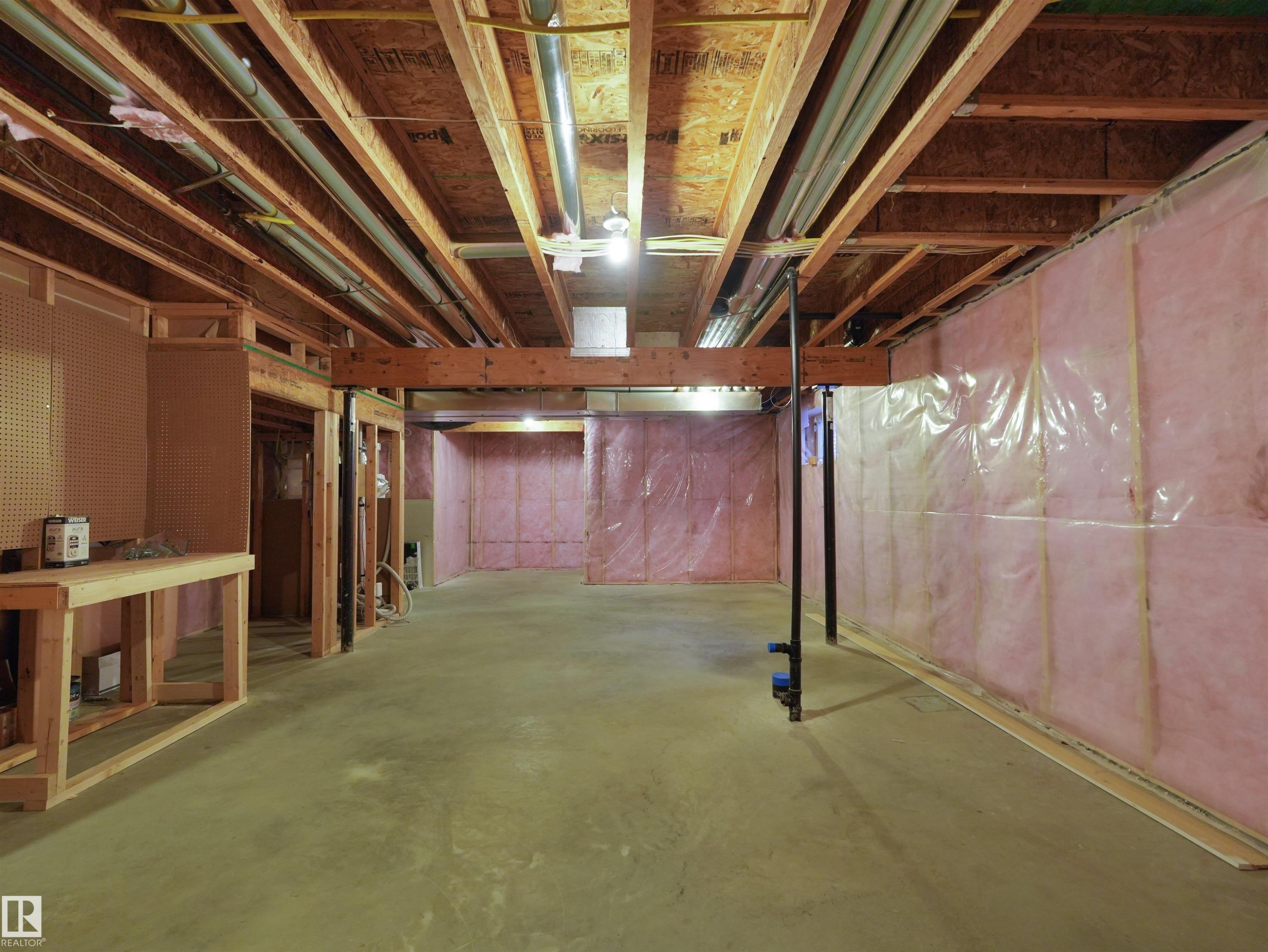 Unfinished basement with concrete flooring, exposed wood framing, and pink insulation - 5190 1B Avenue Sw, Edmonton, AB