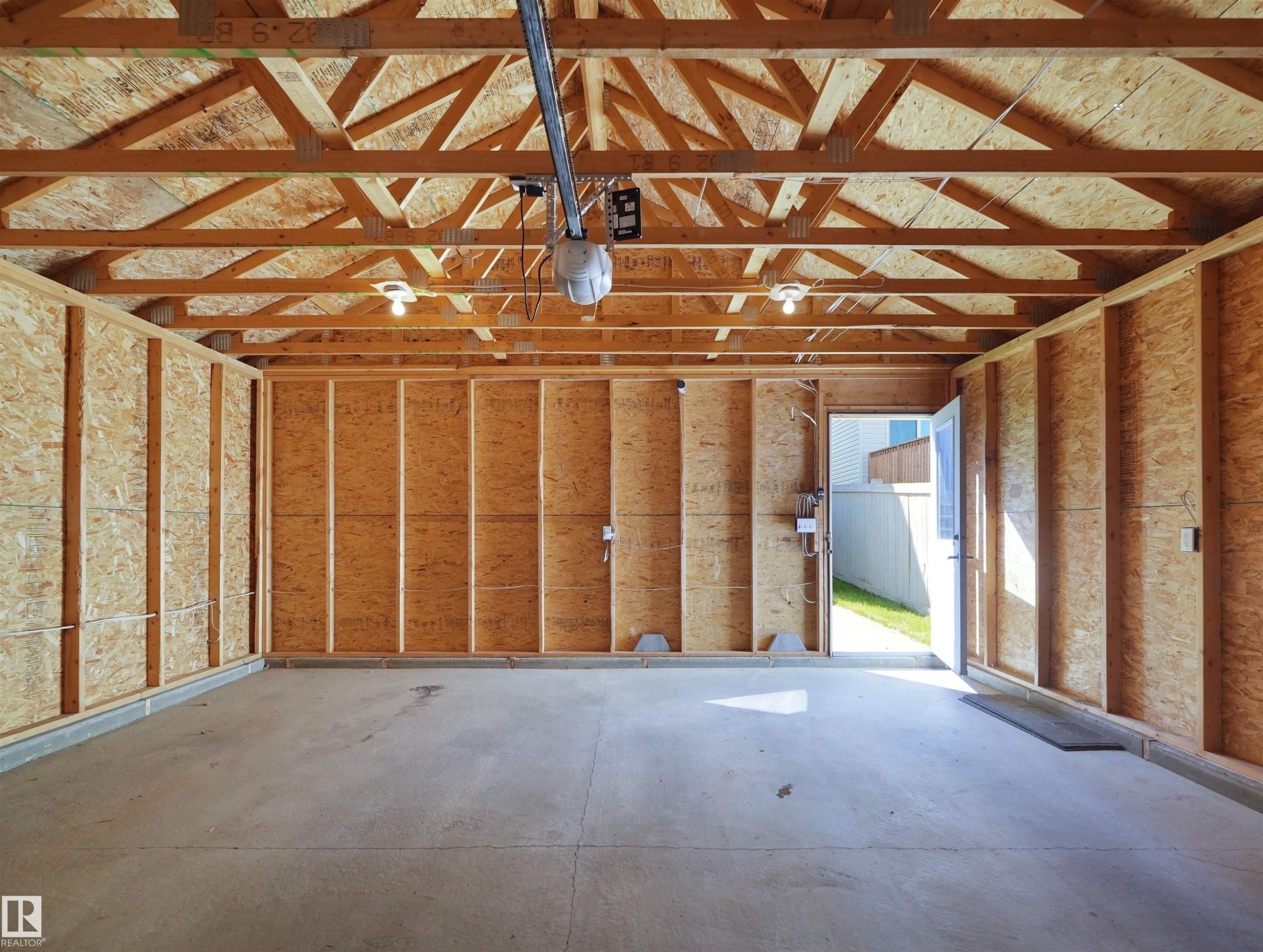 Exposed wood framing, concrete flooring, overhead lighting, and an automatic garage door opener - 5190 1B Avenue Sw, Edmonton, AB