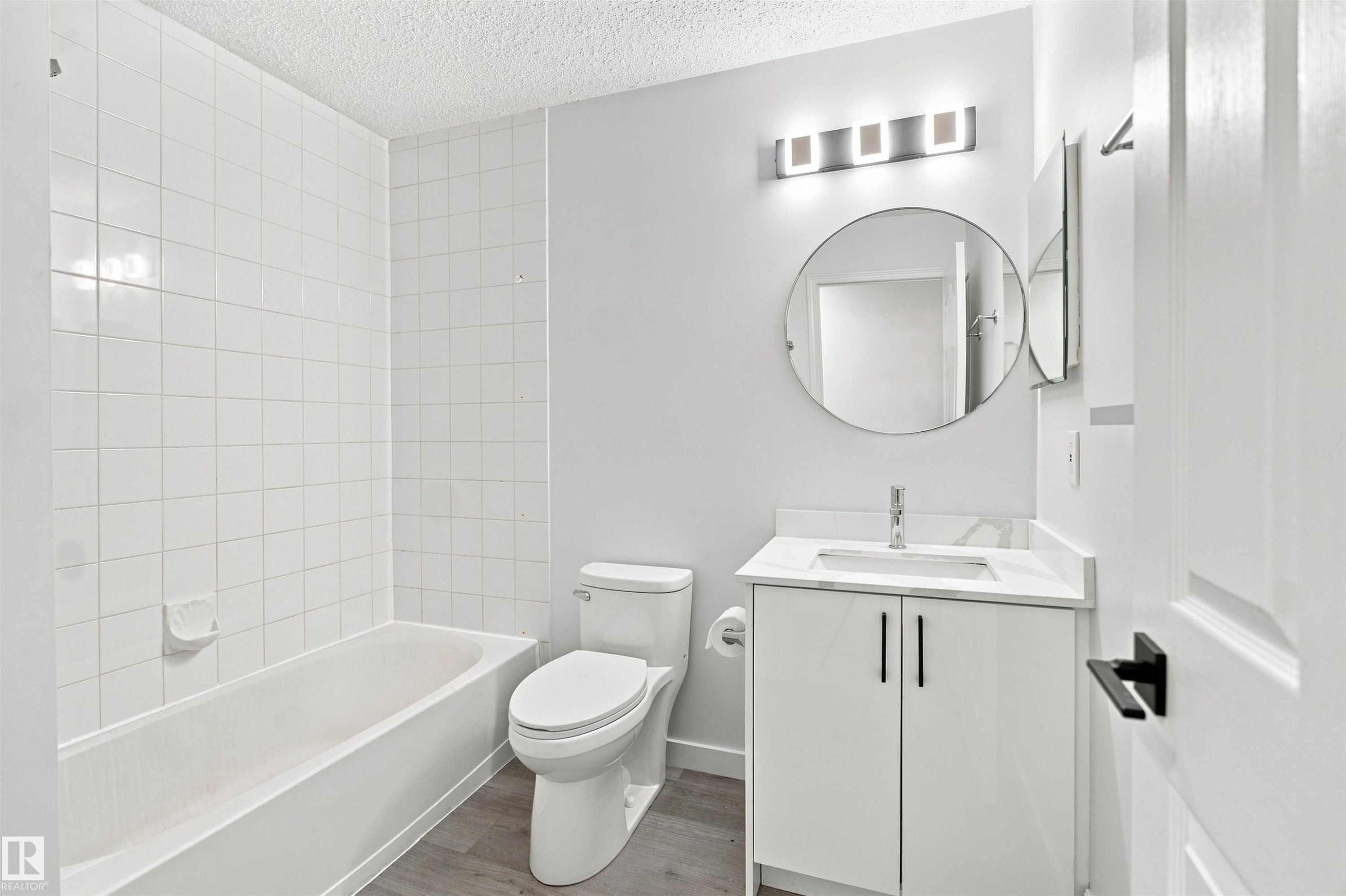 White vanity with a rectangular basin, chrome faucet, and matte black hardware - #124 10511 42 Av Nw, Edmonton, AB