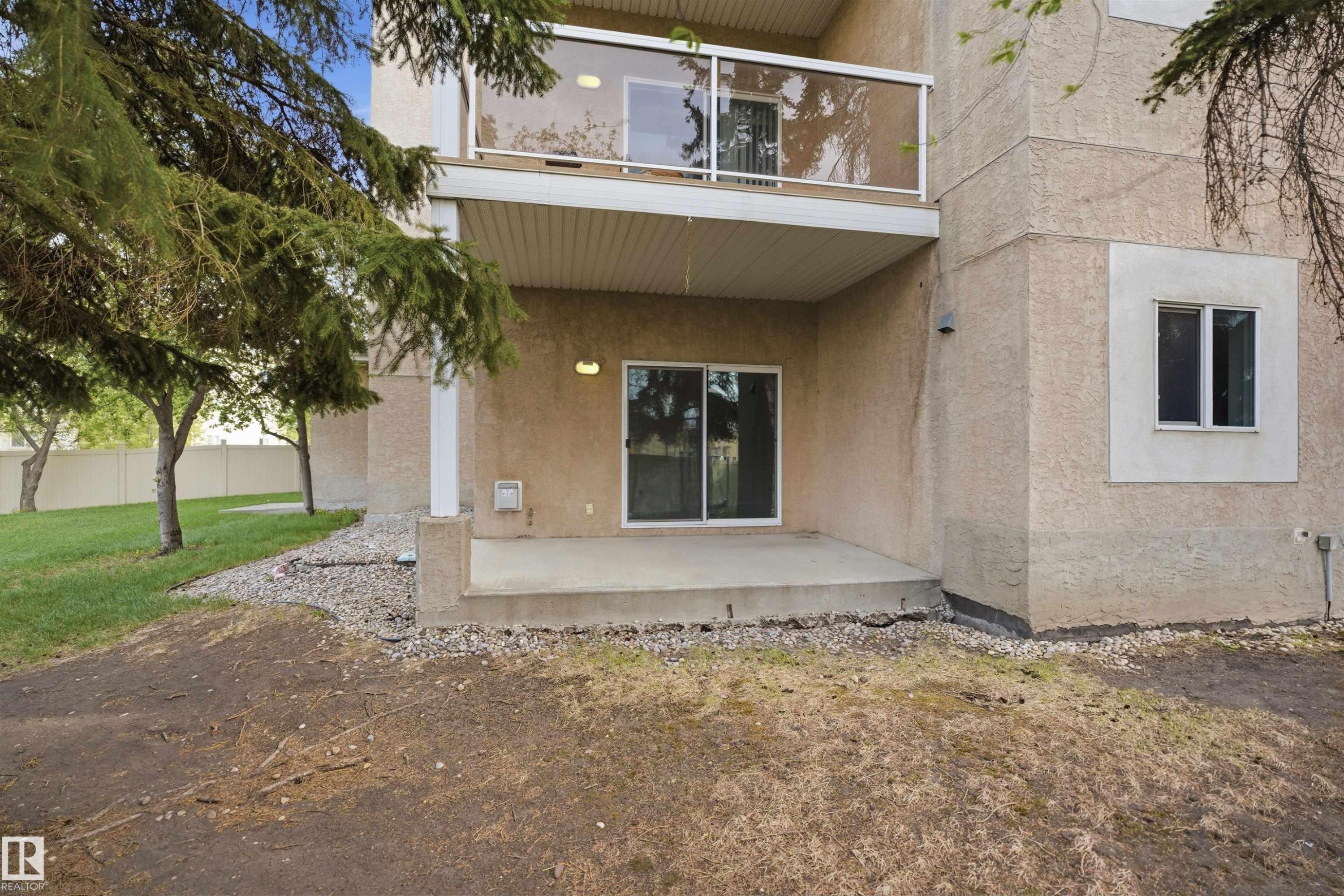 Ground-level concrete patio with sliding glass door access - #124 10511 42 Av Nw, Edmonton, AB