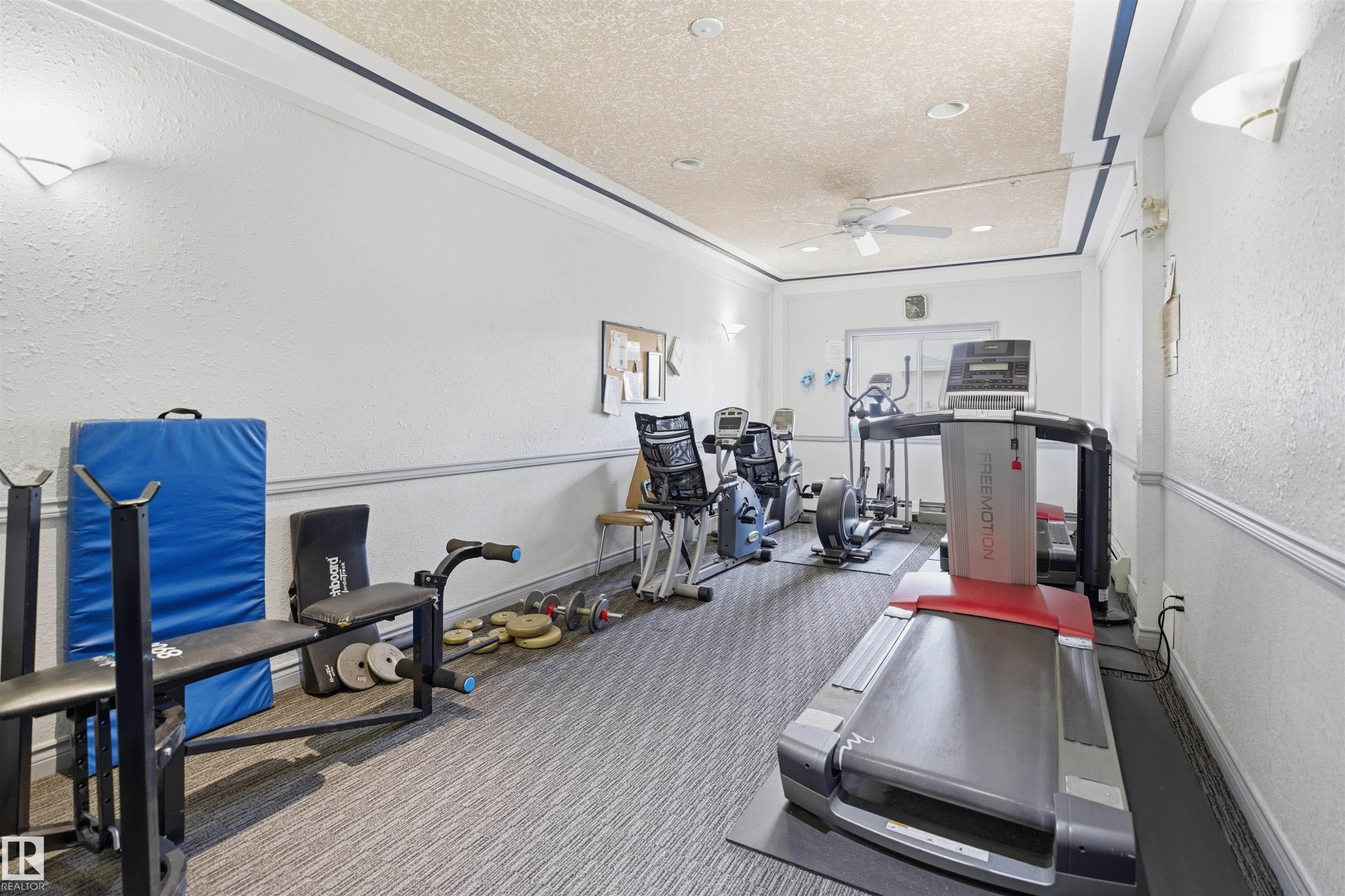 Dedicated fitness room with textured wall finish and ceiling fan - #124 10511 42 Av Nw, Edmonton, AB