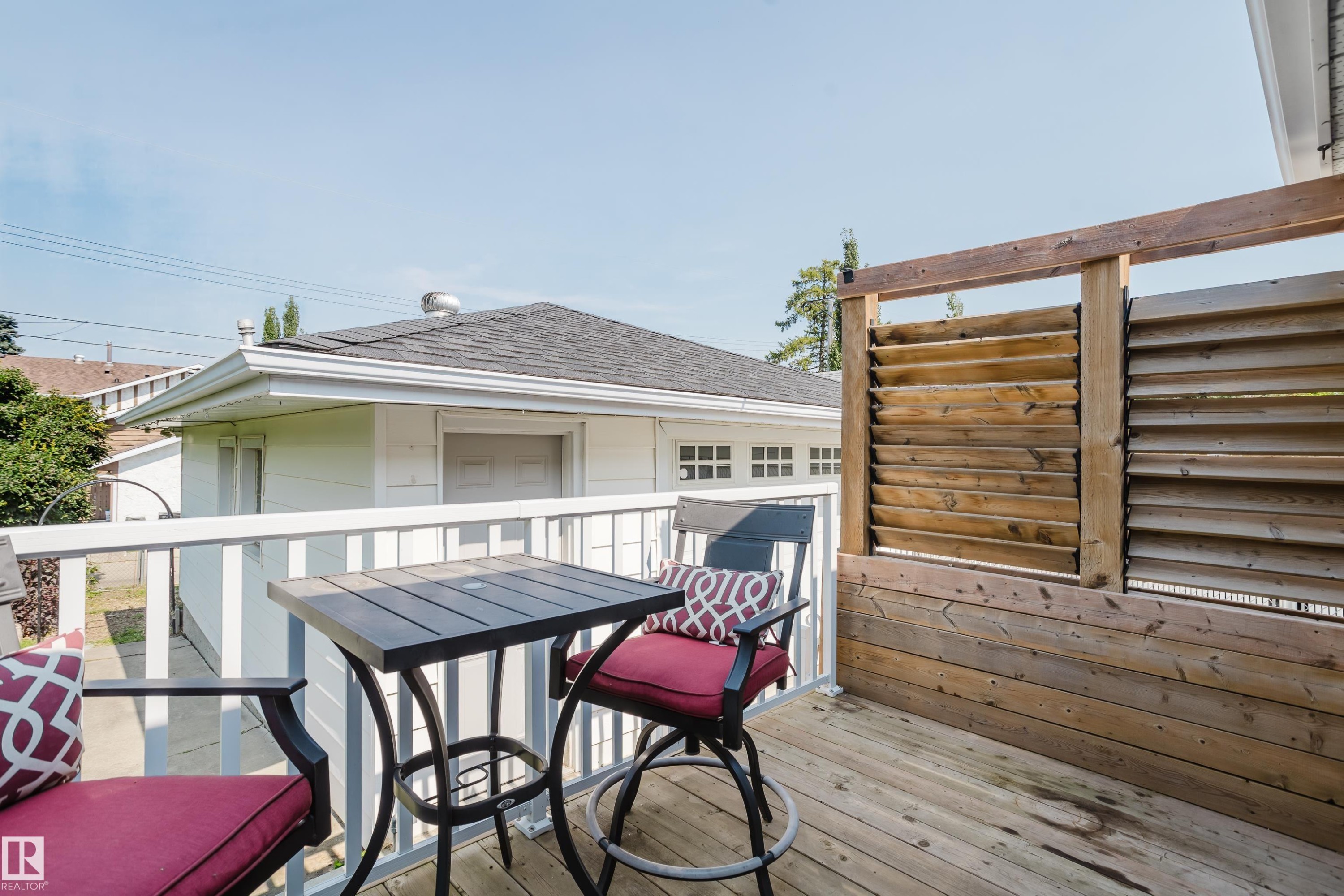 Deck with wood plank flooring and a slatted wood privacy wall - 4708 106 Avenue Nw, Edmonton, AB