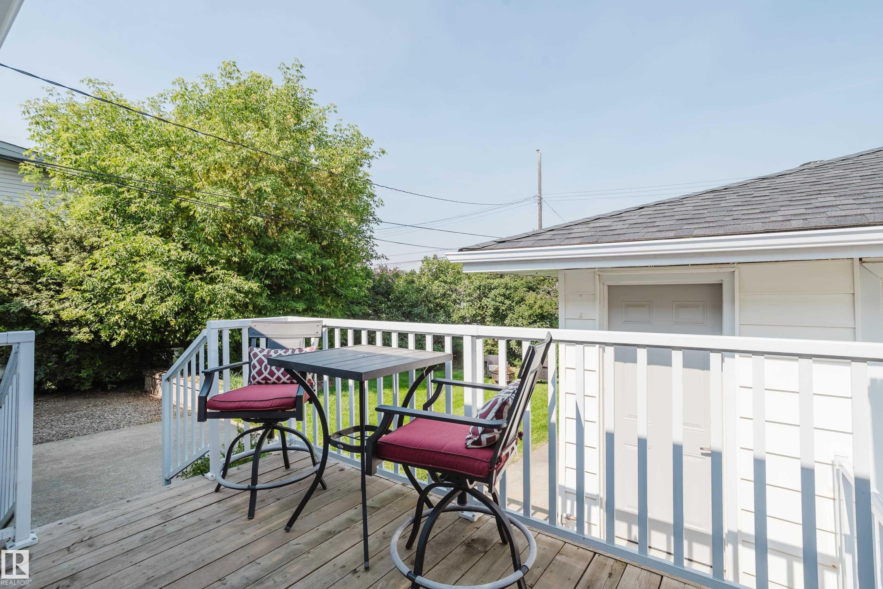Wood-finish deck with white railings and an outdoor stairwell - 4708 106 Avenue Nw, Edmonton, AB