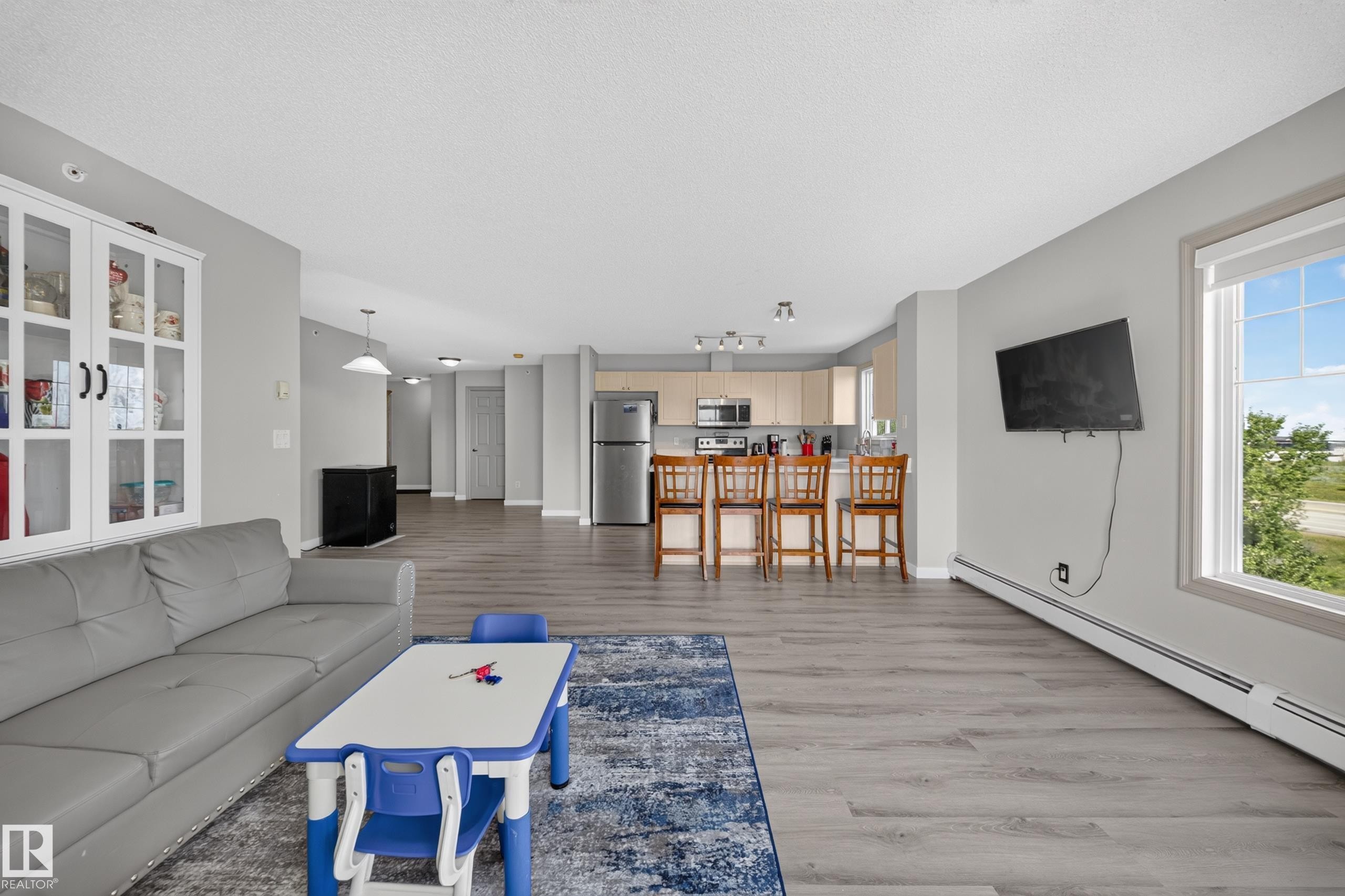 Open concept living space with wood-finish flooring - #419 4407 23 St Nw, Edmonton, AB