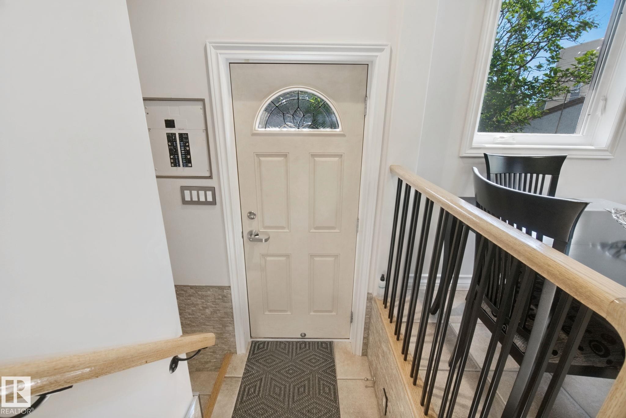 Entry door with an arched decorative glass insert and a security deadbolt - 12916 63 Street Nw, Edmonton, AB