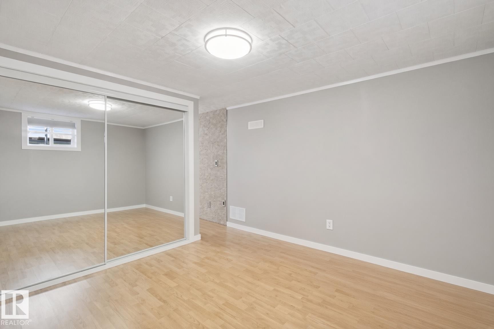 Wood-finish flooring, mirrored sliding doors, recessed window, flush-mount ceiling light - 12916 63 Street Nw, Edmonton, AB