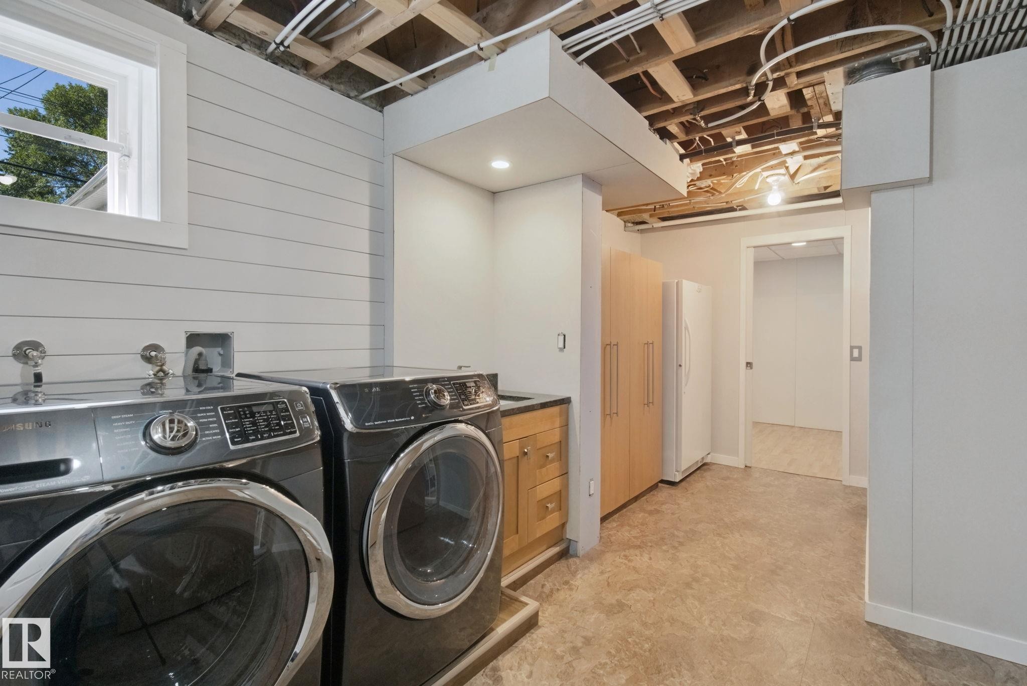Utility space featuring a window, shiplap wall, built-in cabinetry, and recessed lighting - 12916 63 Street Nw, Edmonton, AB