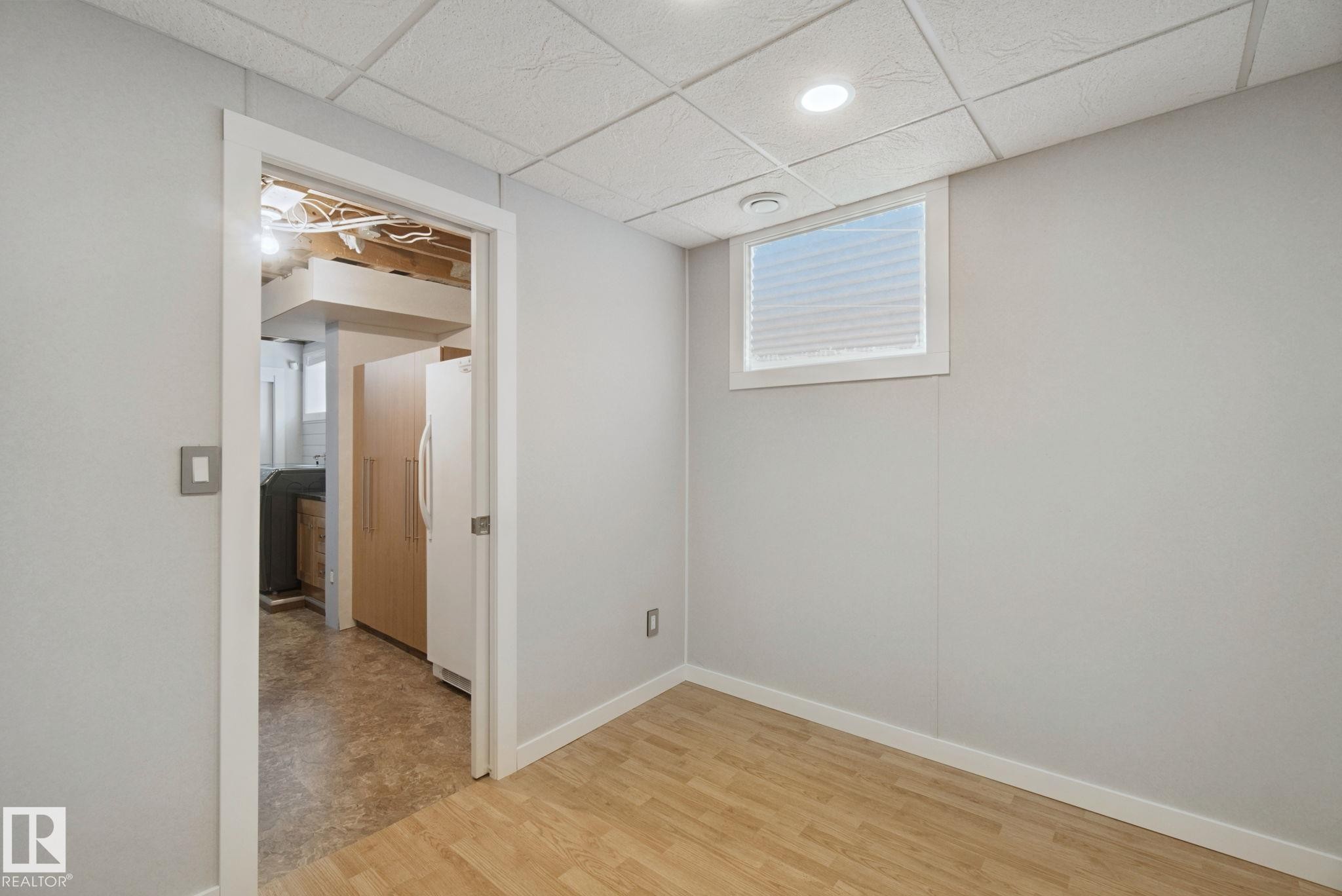 Wood-finish flooring, recessed ceiling lighting, and a window with blinds - 12916 63 Street Nw, Edmonton, AB
