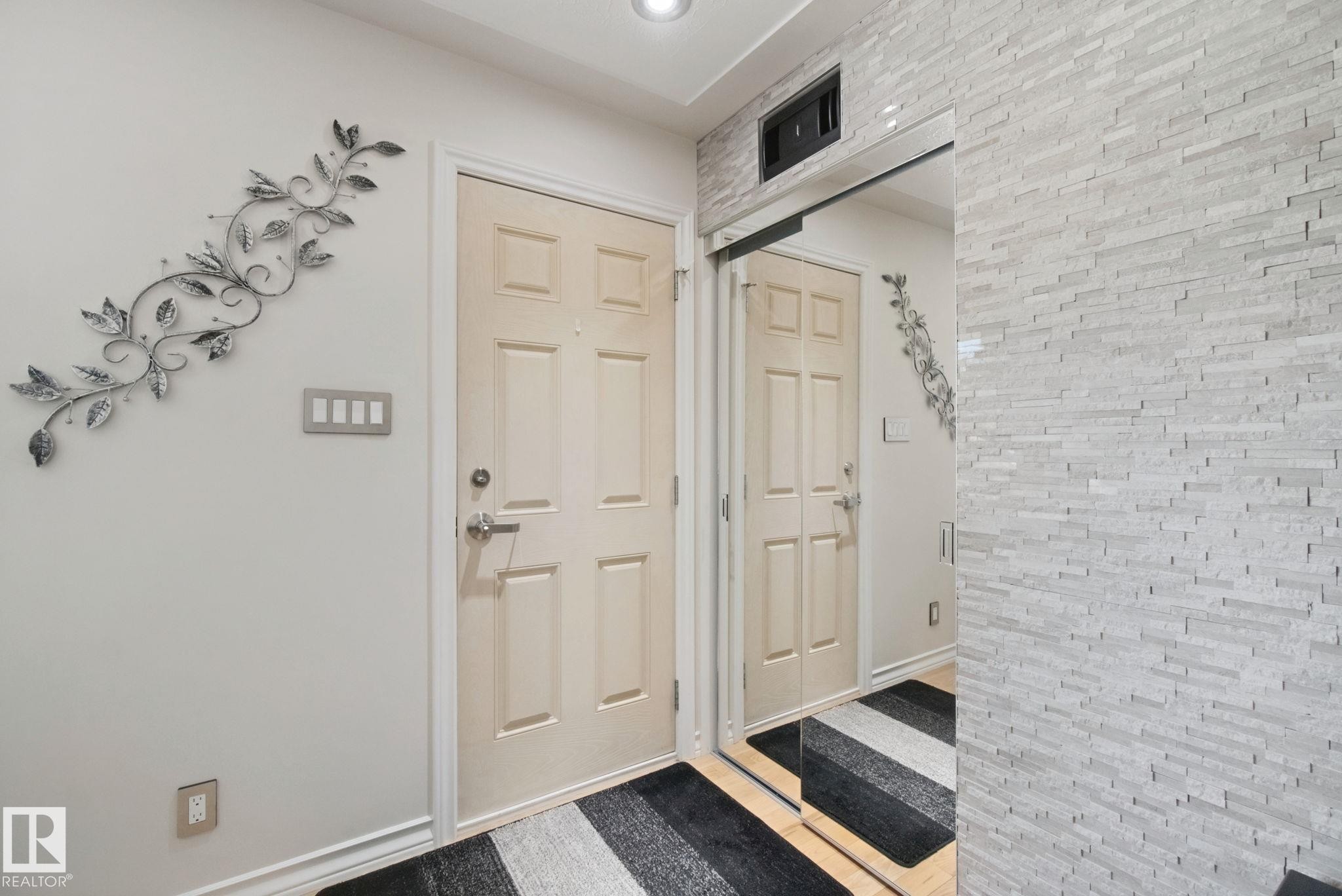 Recessed lighting illuminates the entryway, featuring a paneled door with brushed nickel hardware - 12916 63 Street Nw, Edmonton, AB