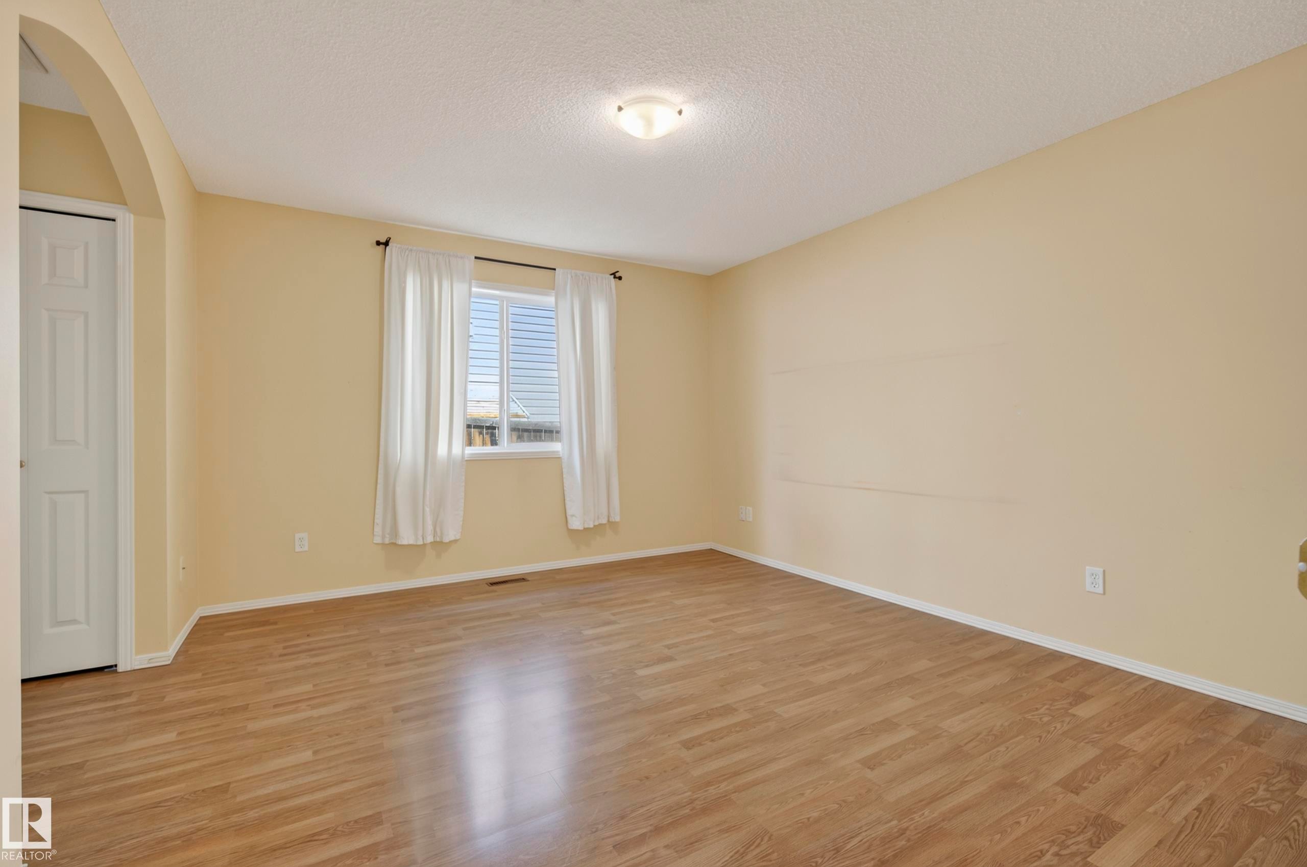 Wood-finish flooring, recessed window, archway entry, and a ceiling-mounted light fixture - 15213 49A Street Nw, Edmonton, AB
