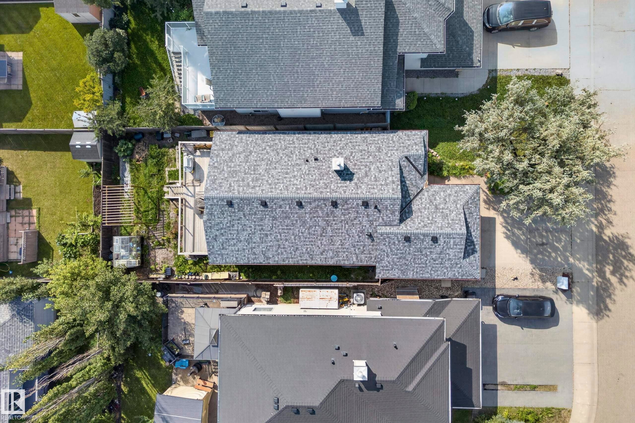 Gabled roofline with asphalt shingles, featuring a chimney and multiple roof planes - 15213 49A Street Nw, Edmonton, AB