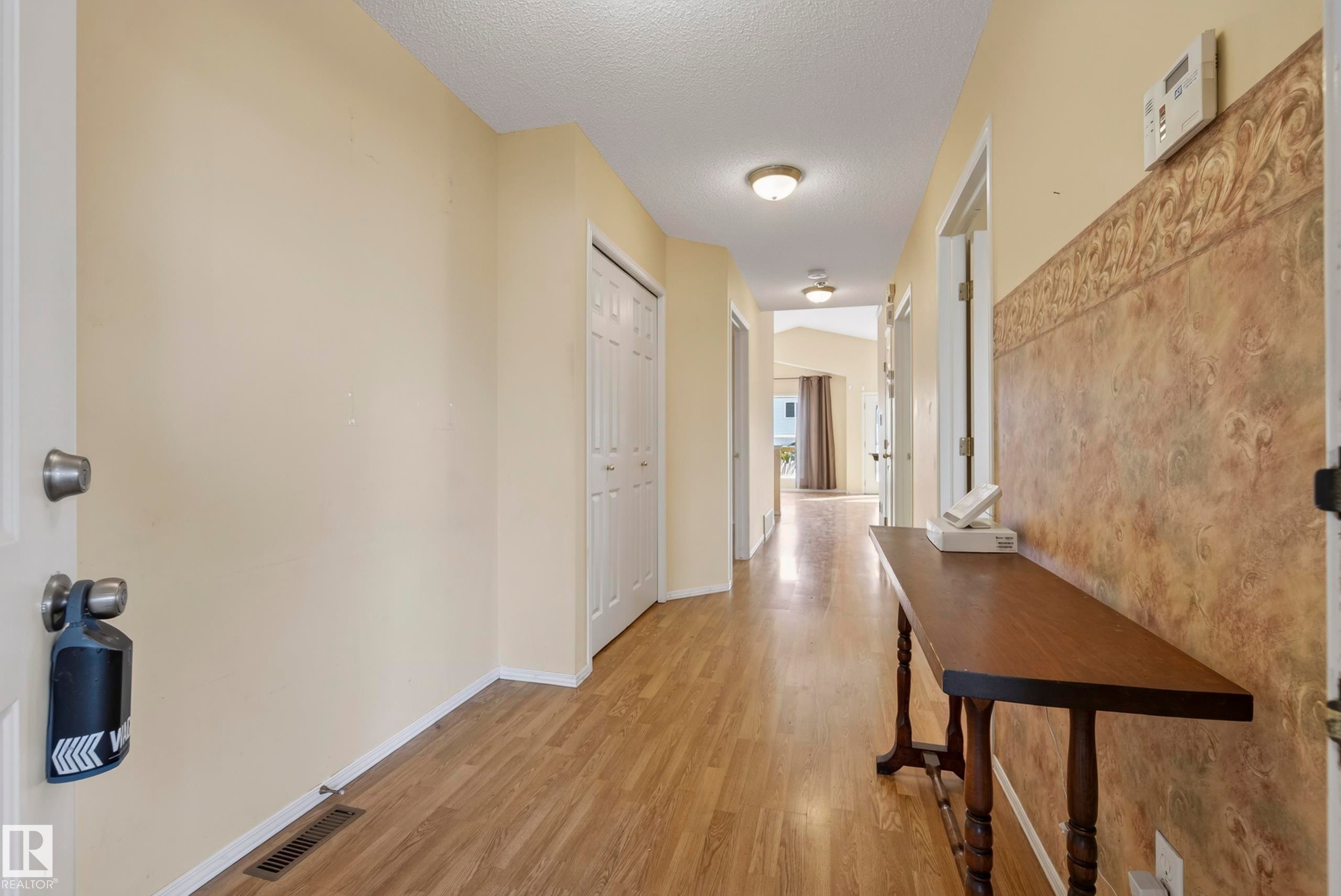 Hallway featuring wood-finish flooring, neutral wall tones, and recessed lighting - 15213 49A Street Nw, Edmonton, AB