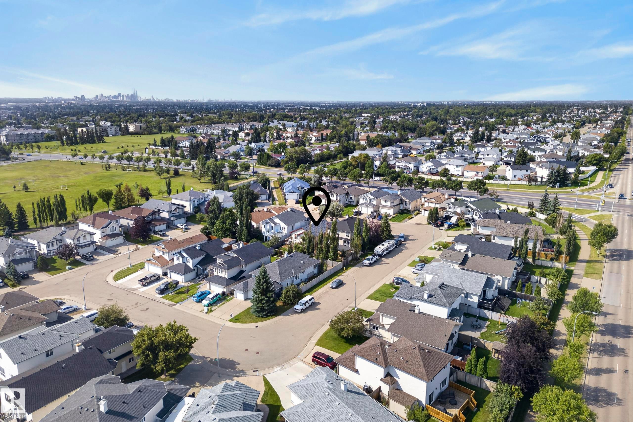 Residential neighborhood featuring tree-lined streets and a distant urban skyline - 15213 49A Street Nw, Edmonton, AB