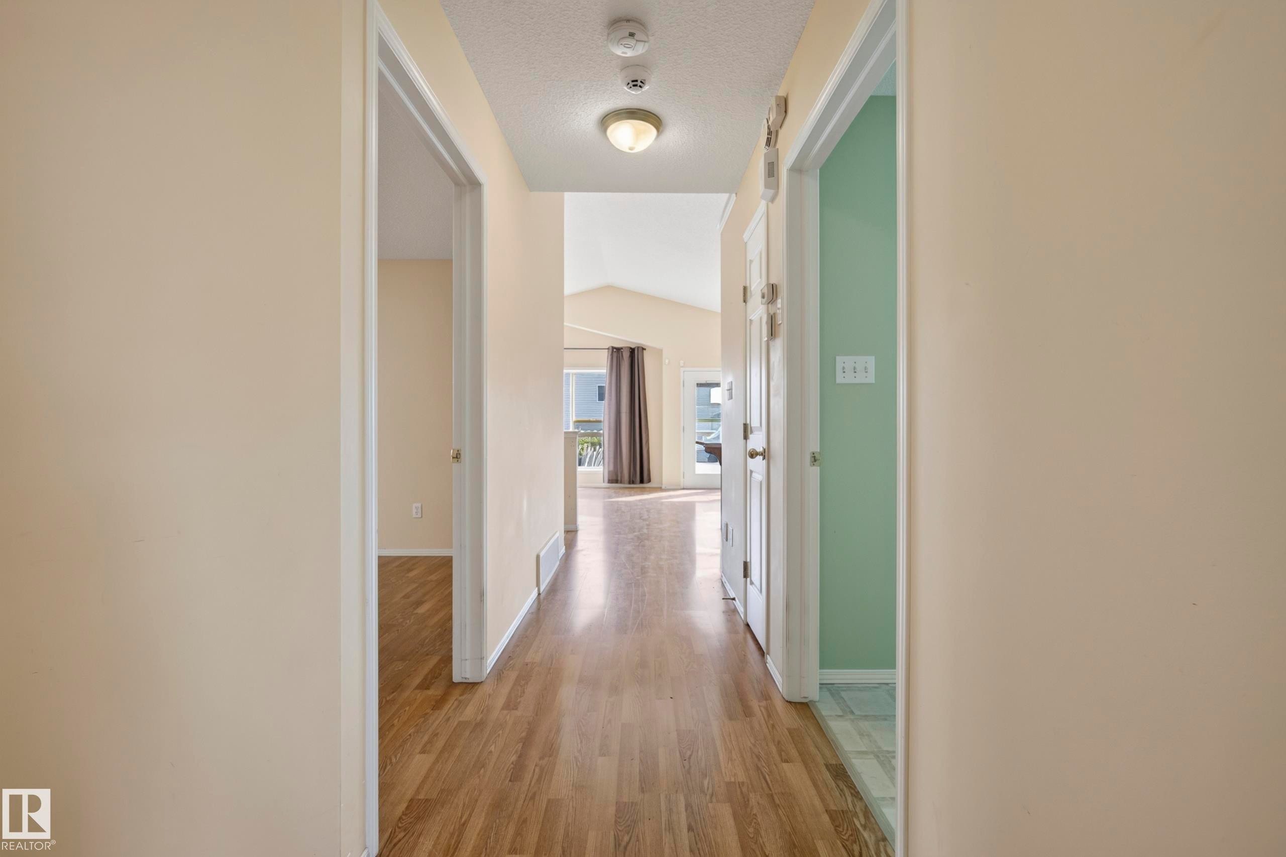 Hallway with wood-finish flooring, neutral wall tones, and recessed ceiling lighting - 15213 49A Street Nw, Edmonton, AB