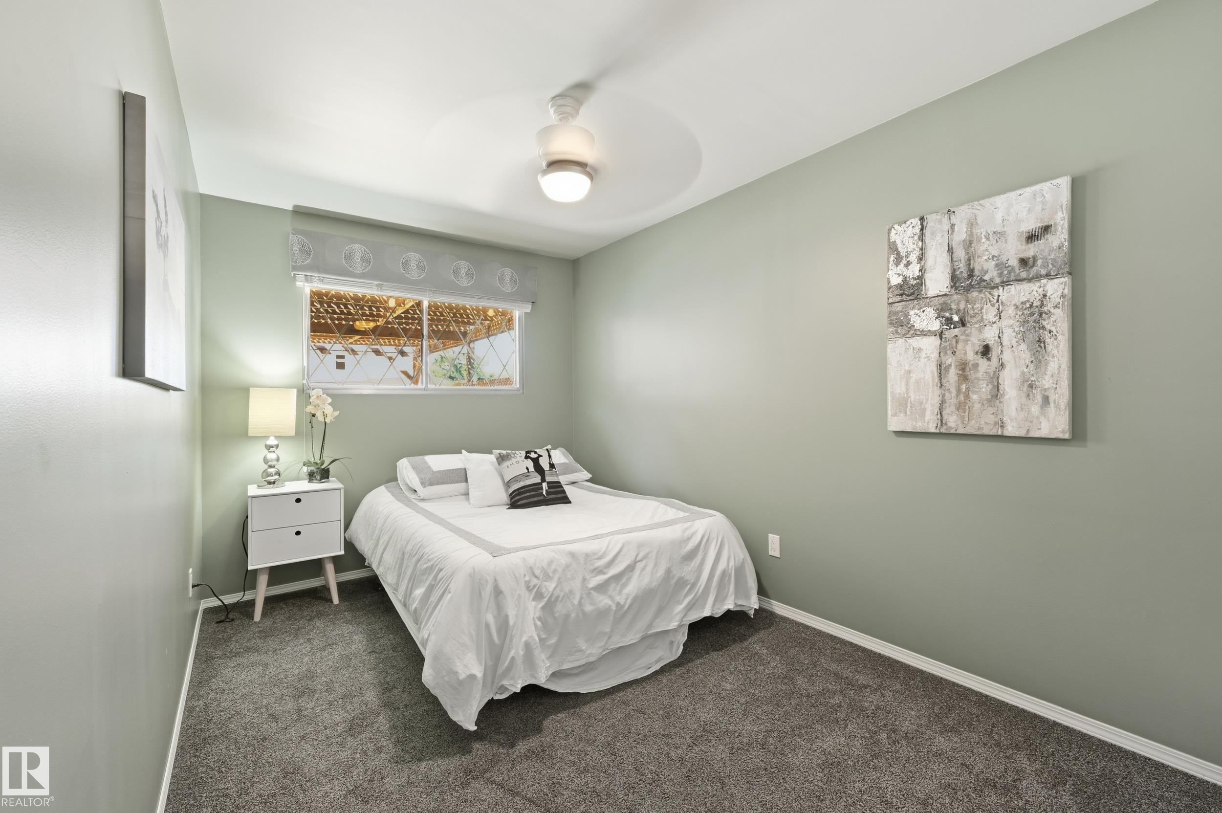 Room featuring neutral wall color, overhead ceiling fan with lighting, and a large window with a valance - 10552 45 Street Nw, Edmonton, AB