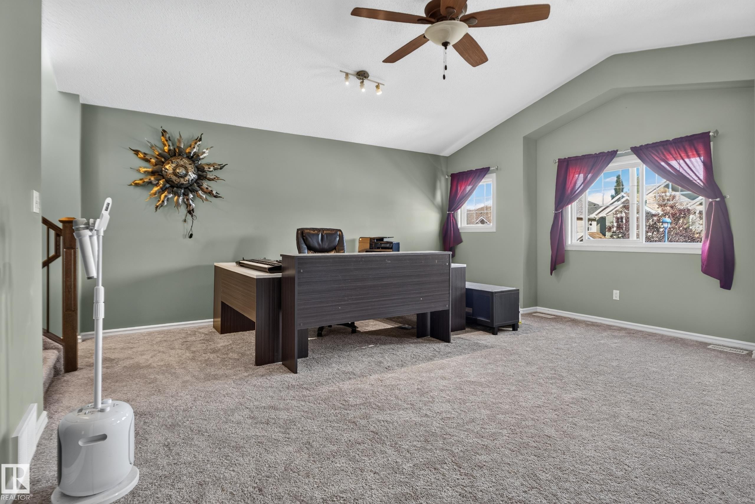 Carpeted room with vaulted ceilings, a ceiling fan, and multiple windows - 1332 72 Street Sw, Edmonton, AB