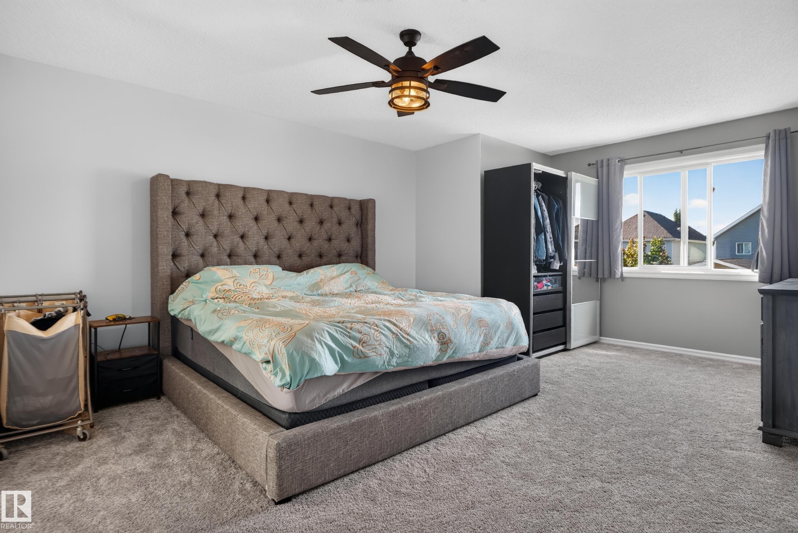 Plush carpeting, a ceiling fan with integrated lighting, and multiple windows with curtain rods - 1332 72 Street Sw, Edmonton, AB